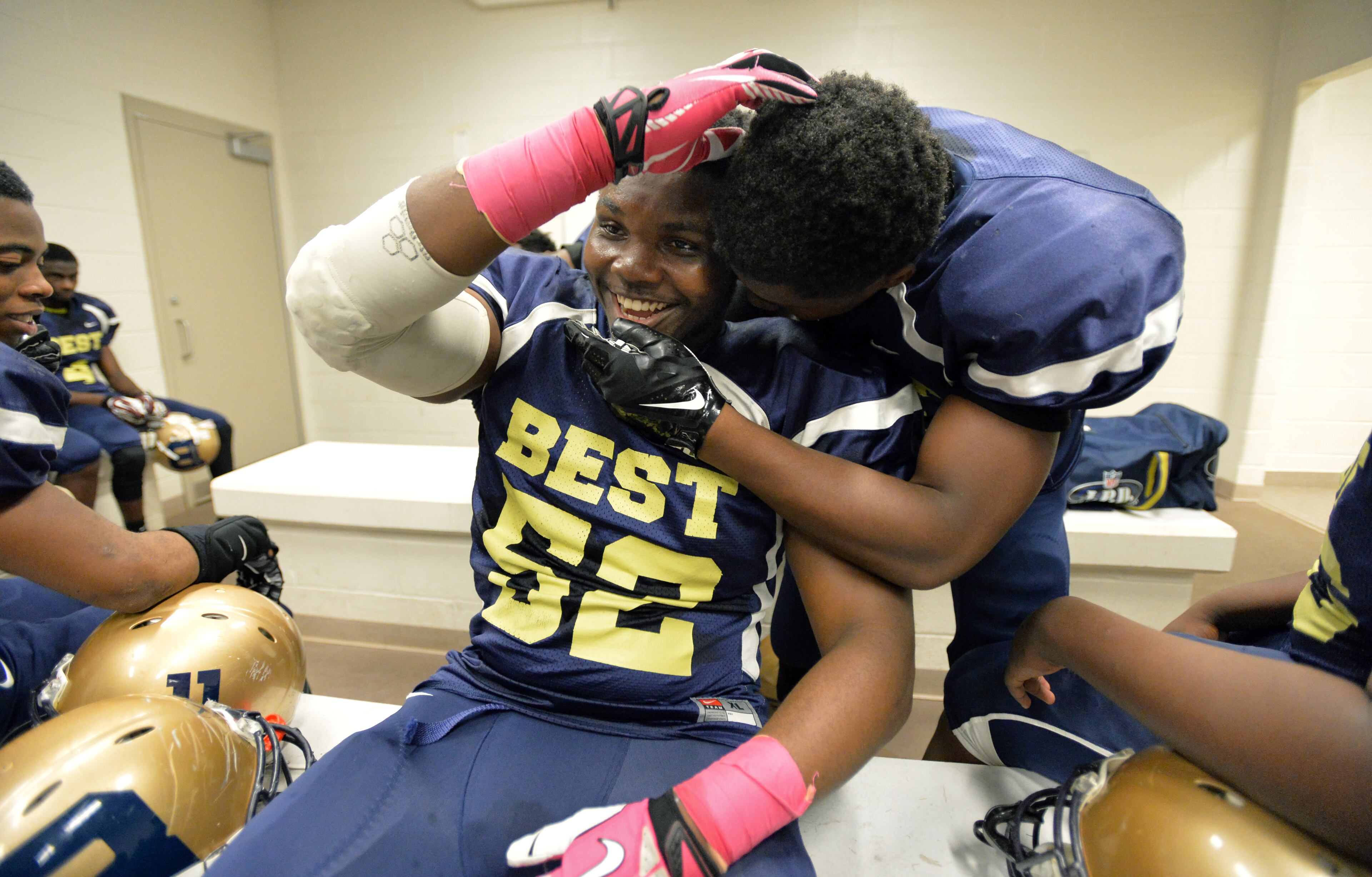 Darius Marshall (sitting), 18, shares a laugh with his B.E.S.T Academy teammate Terrion Riley before their game against the Wesleyan school at Grady High School stadium on Friday, October 10, 2014. HYOSUB SHIN / HSHIN@AJC.COM