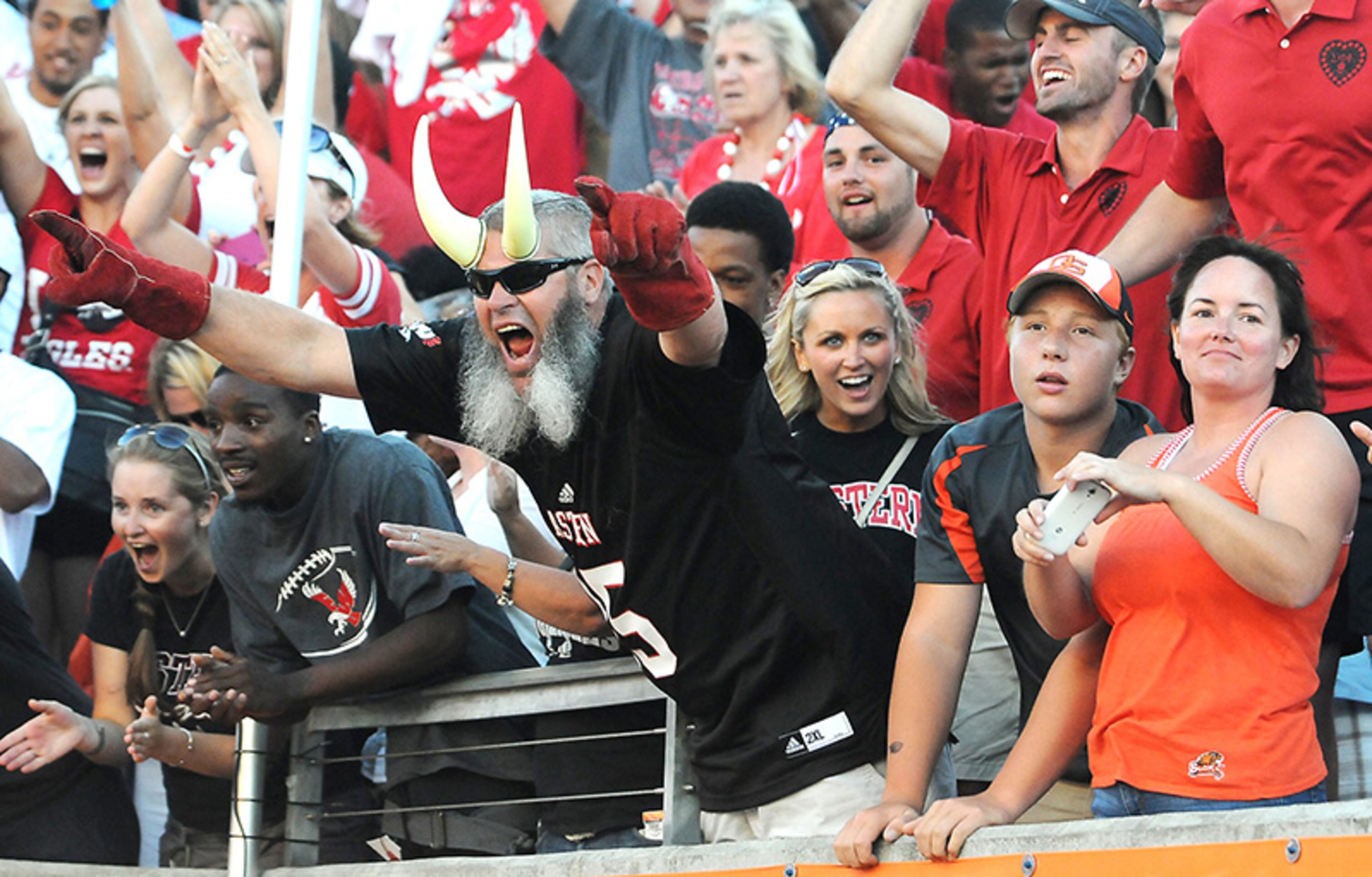 Mark Gehring, center, father of an Eastern Washington player, cheers as a pair of Beaver fans, Garrett Barnes, 13, and aunt Lori Barnes watch the Eagle's celebration over Oklahoma State, Saturday, Aug. 31, 2013, during an NCAA college football game at Reser Stadium in Corvallis, Ore.