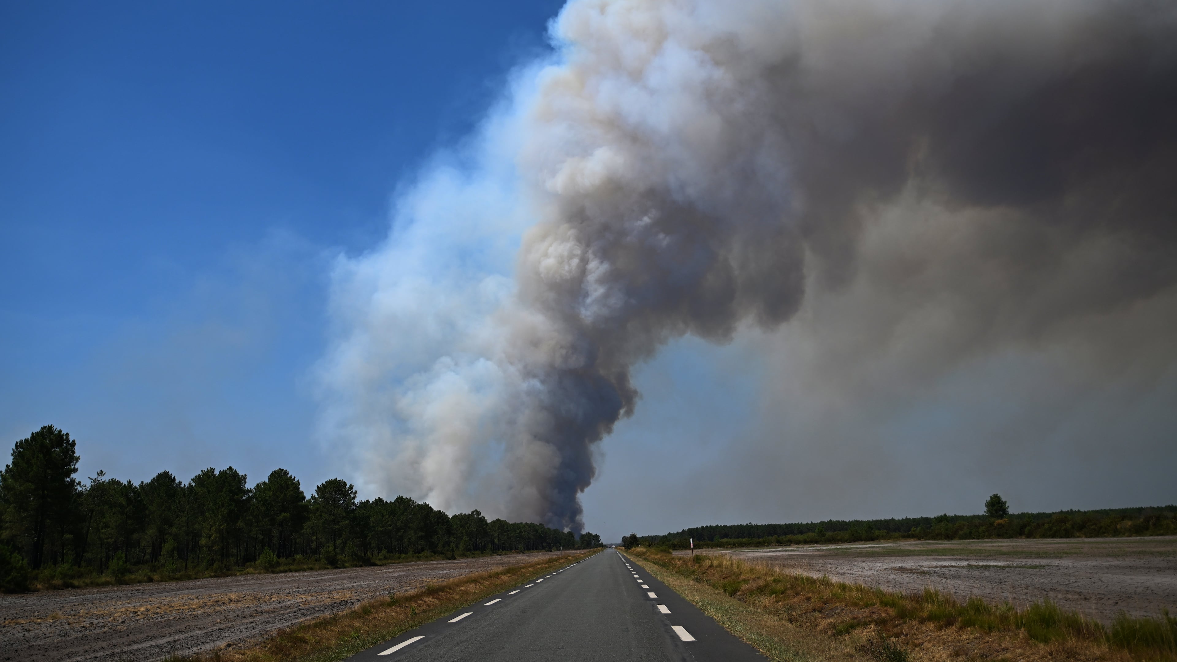 Smoke rises above a road near Saint-Jean-d'Illac, during wildfires in southwestern France, Tuesday, July 28, 2026. (AP Photo/Emma Da Silva)