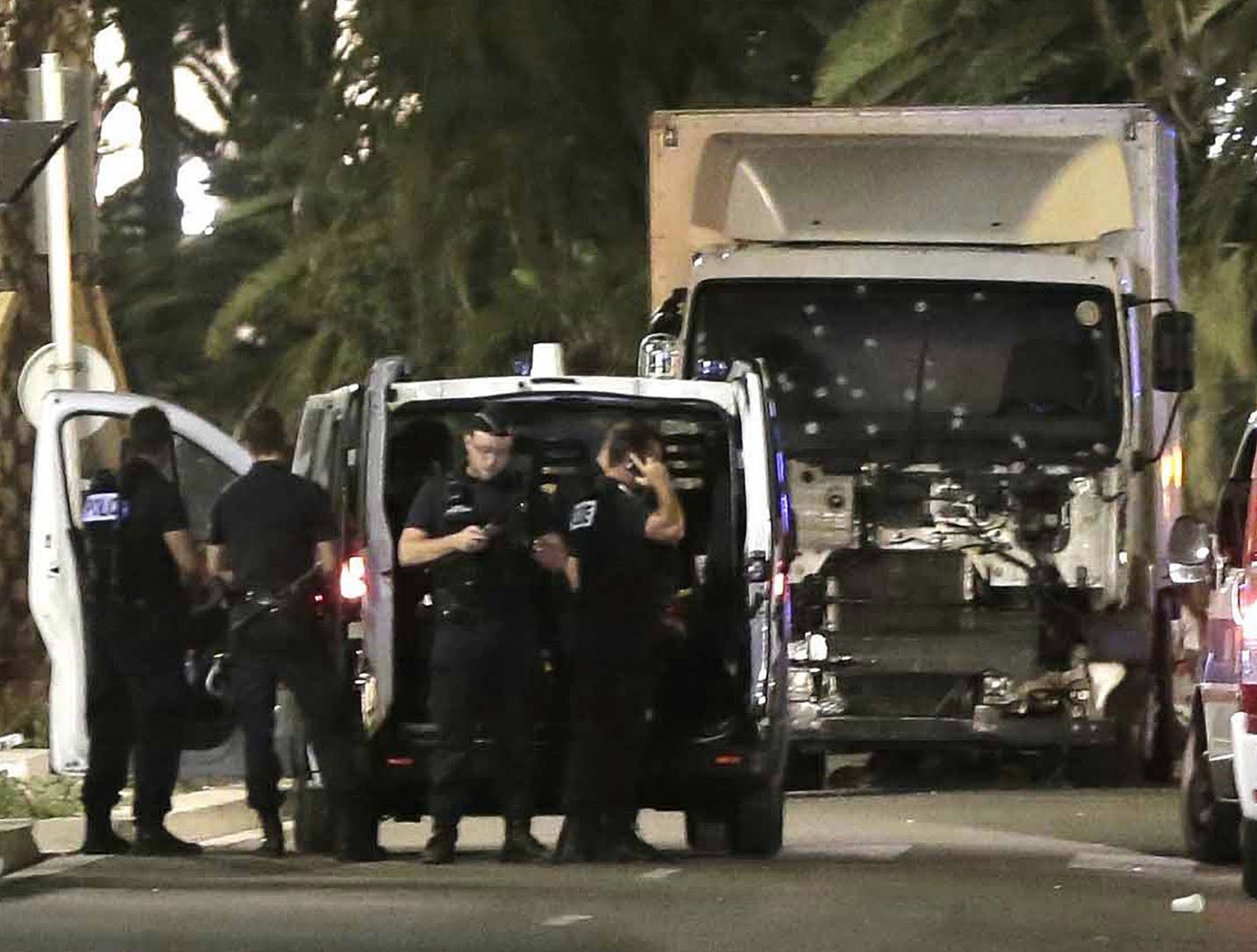 Police officers stand near a van, with its windscreen riddled with bullets, on the Promenade des Anglais in Nice, France, on Thursday, July 15, 2016. The truck sped into a crowd during Bastille Day celebrations in the southern French city, killing dozens. The driver was killed by police. (Franck Fernandes/Maxppp/Zuma Press/TNS)