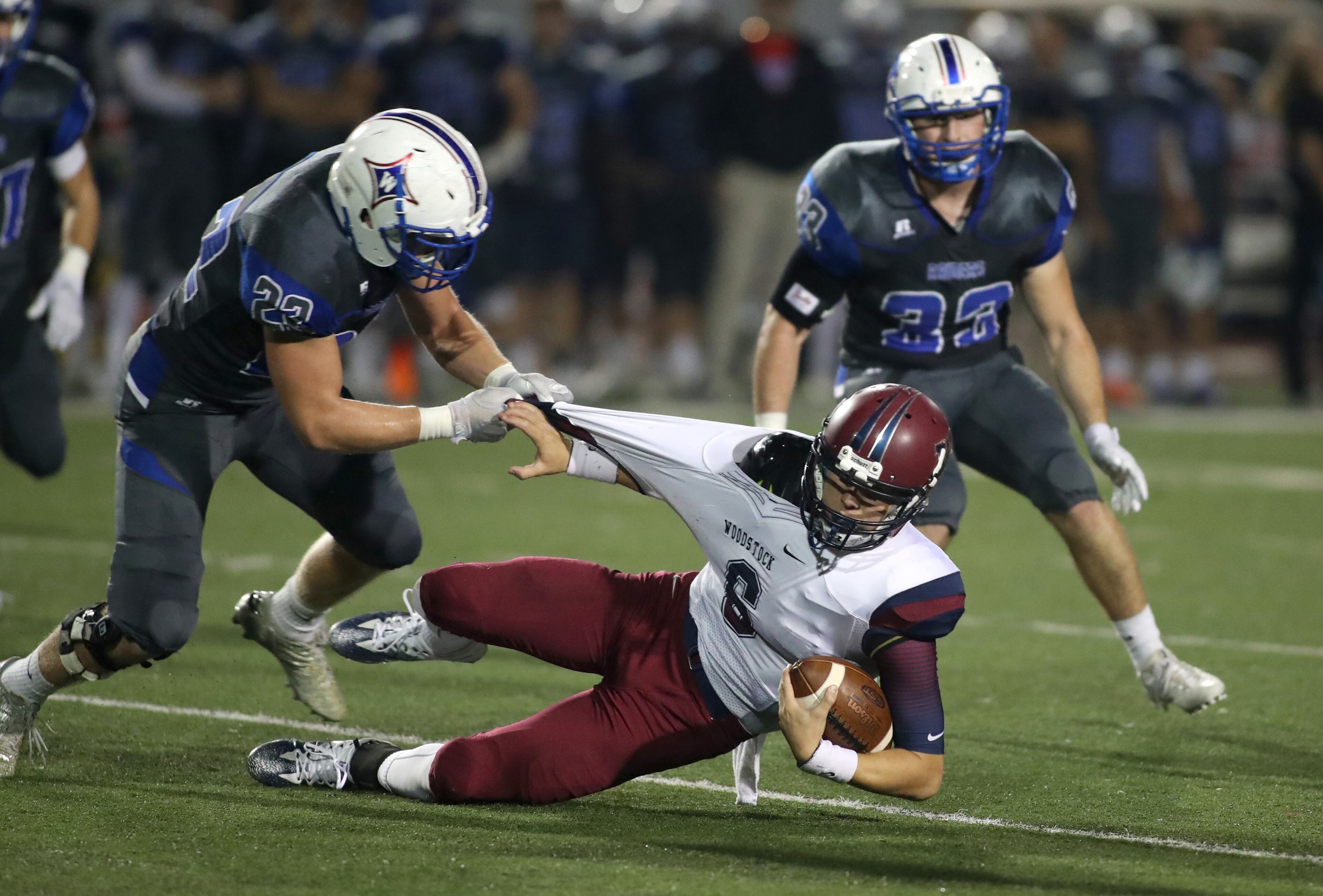 Walton linebacker Dawson Victor (22) brings down Woodstock quarterback Garrett Bass (6) by his jersey in the first half of their game at Walton High School Friday, November 3, 2017, in Marietta. PHOTO / JASON GETZ