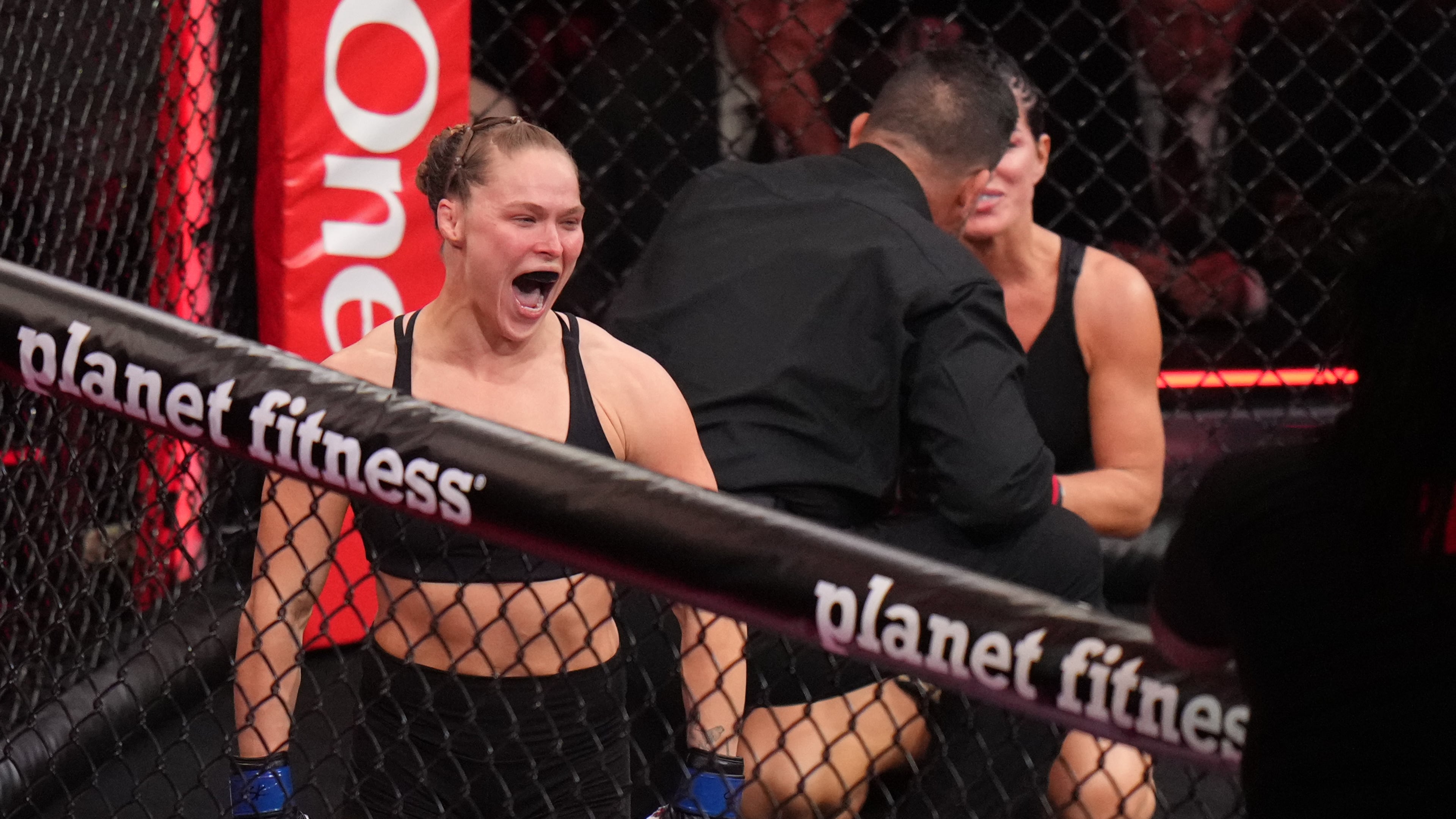 Ronda Rousey, of the United States, left, celebrates after defeating Gina Carano, of the United States, right, in their featherweight mixed martial arts fight Saturday, May 16, 2026, in Inglewood, Calif. (AP Photo/Jae C. Hong )
