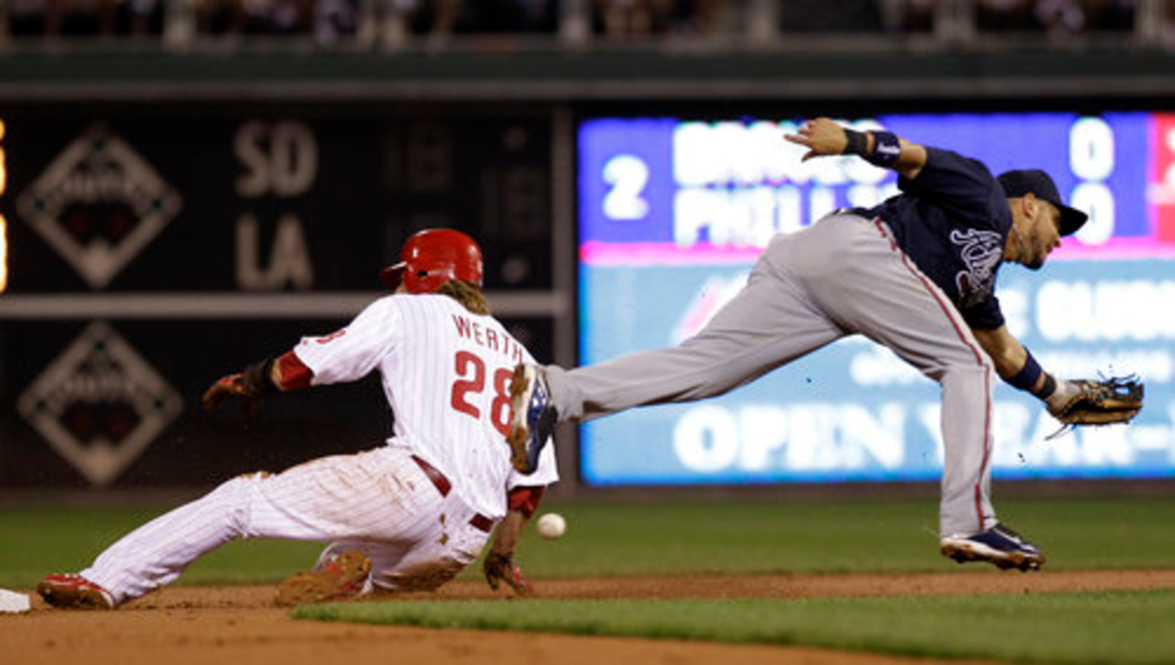 Philadelphia Phillies' Jayson Werth, left, steals second base as Atlanta Braves second baseman Omar Infante tries to handle the errant throw in the second inning of a baseball game, Wednesday, Sept. 22, 2010, in Philadelphia.