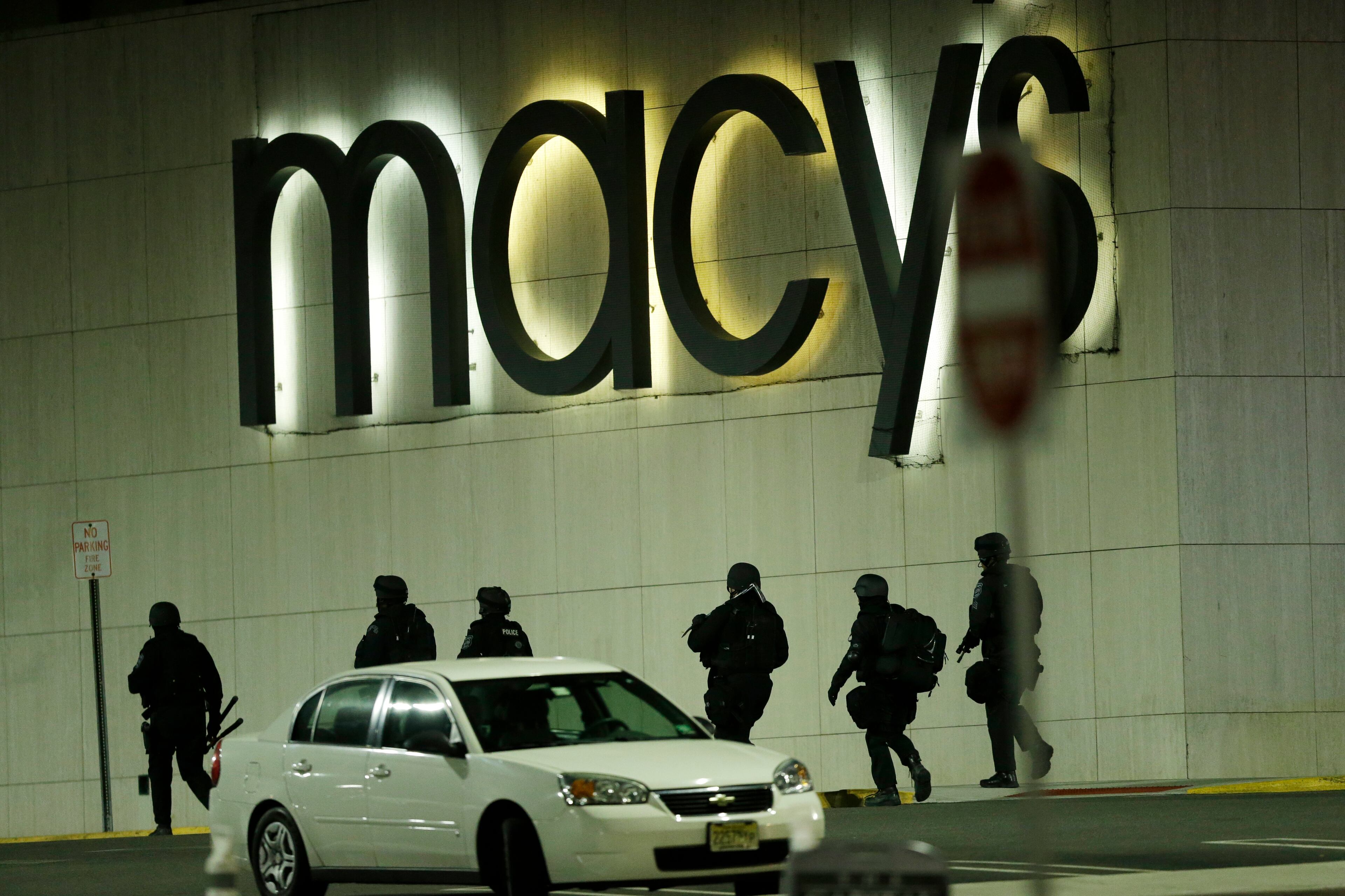 Officials wearing tactical gear walk outside of Garden State Plaza Mall following reports of a shooter, Monday, Nov. 4, 2013, in Paramus, N.J. Hundreds of law enforcement officers converged on the mall Monday night after witnesses said multiple shots were fired there. (AP Photo/Julio Cortez)