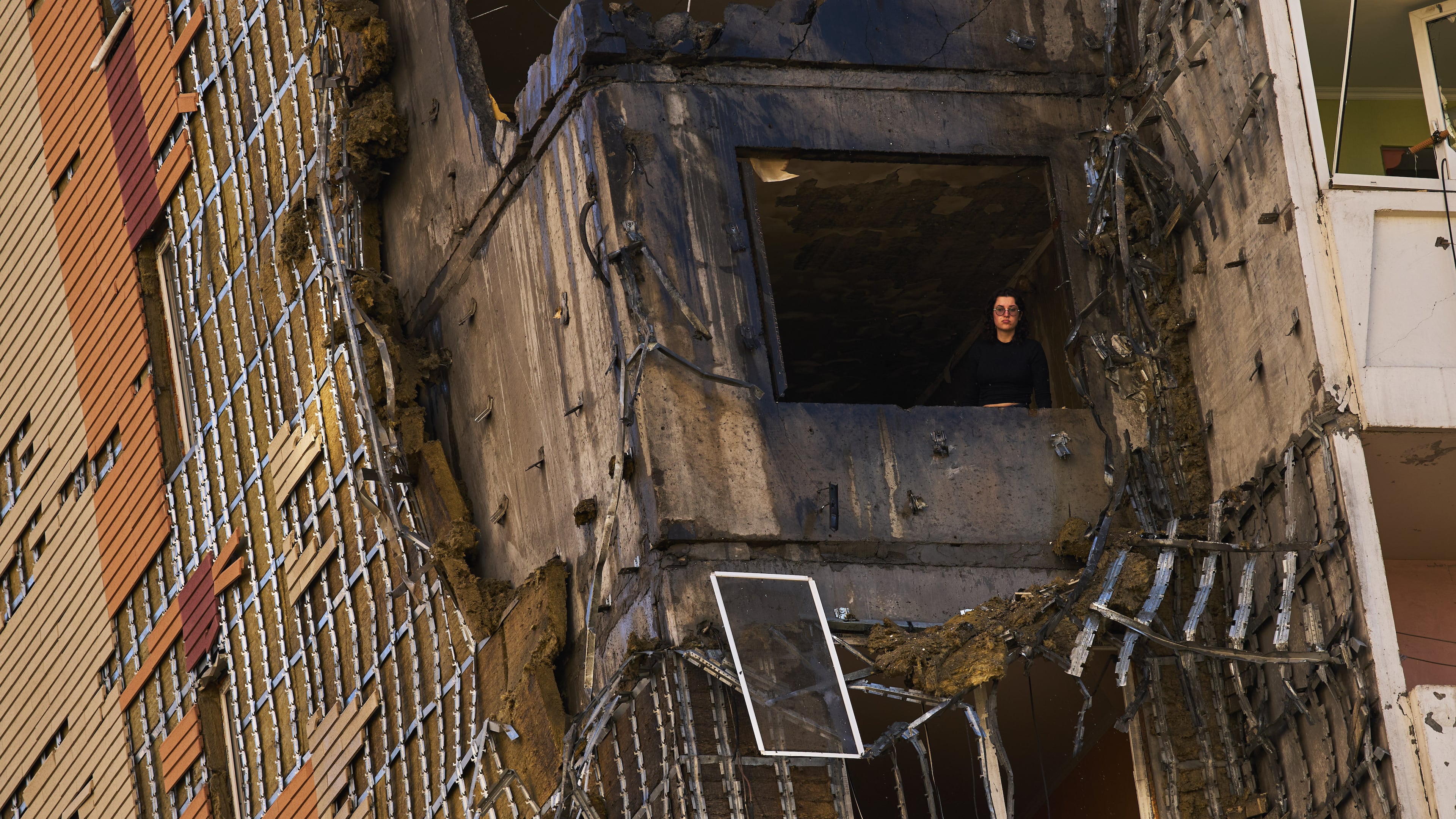 A woman peers from a window of a partially damaged residential building following a Russian drone attack in Kyiv, Ukraine, Wednesday, Sept. 9, 2026. (AP Photo/Francisco Seco)