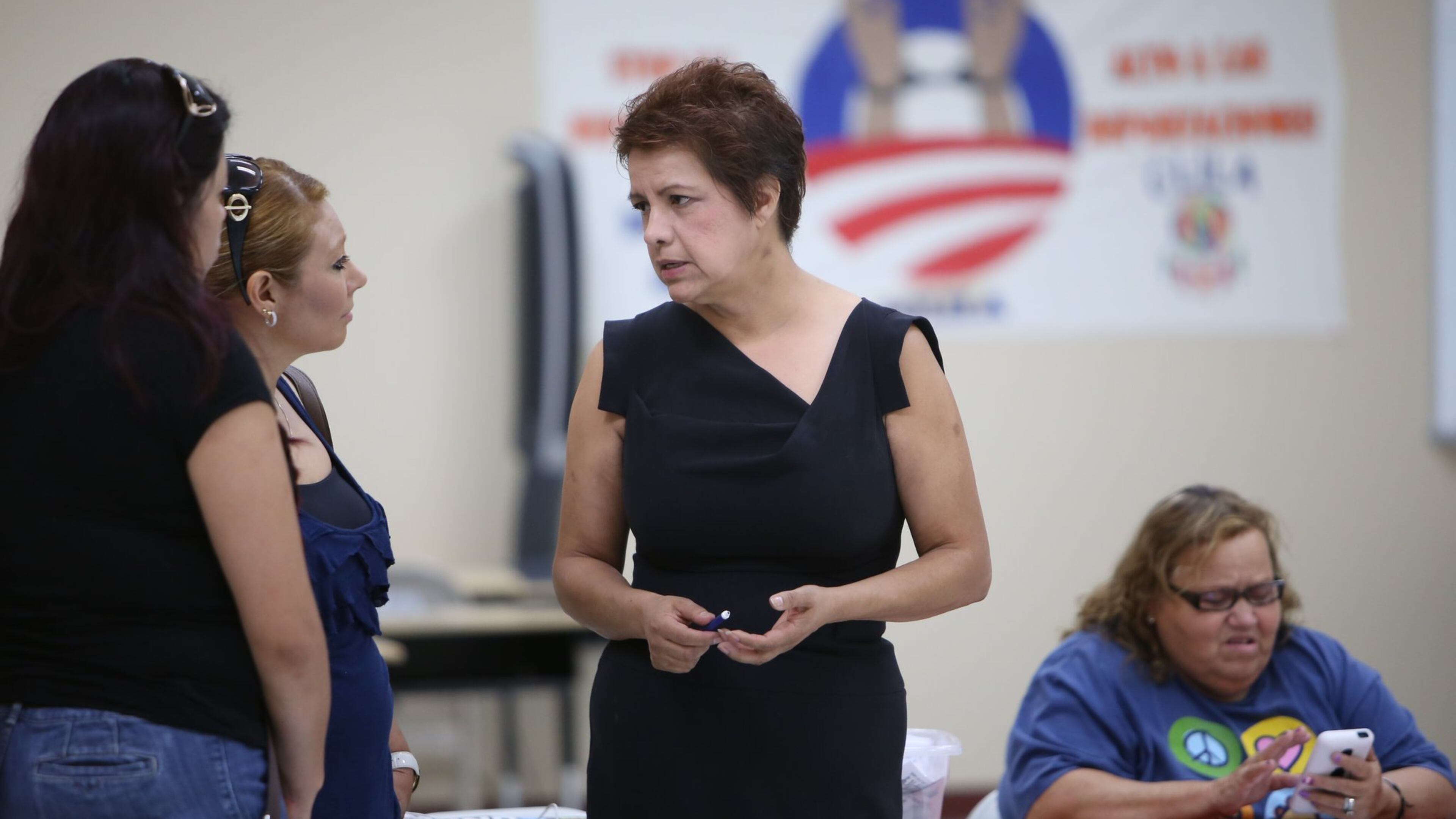 America Gruner (in black), president of the Coalition of Latino Leaders (CLILA), speaks to prospective voters at the organization’s headquarters in Dalton, Ga.