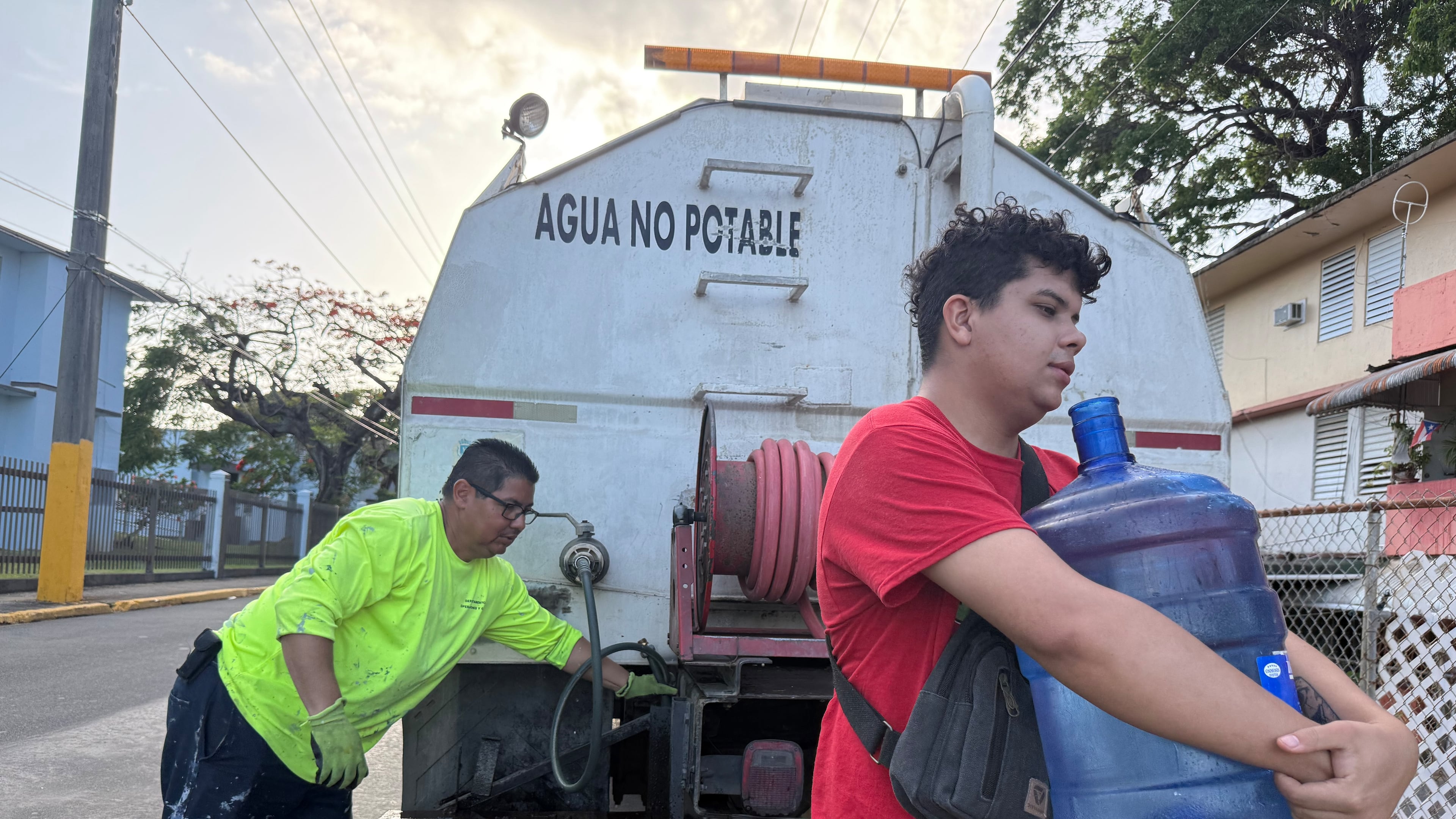 Bryan Pérez hauls a five-gallon water jug to his apartment in the Villa Kennedy public housing complex in San Juan, Puerto Rico, Wednesday, June 10, 2026. (AP Photo/Danica Coto)