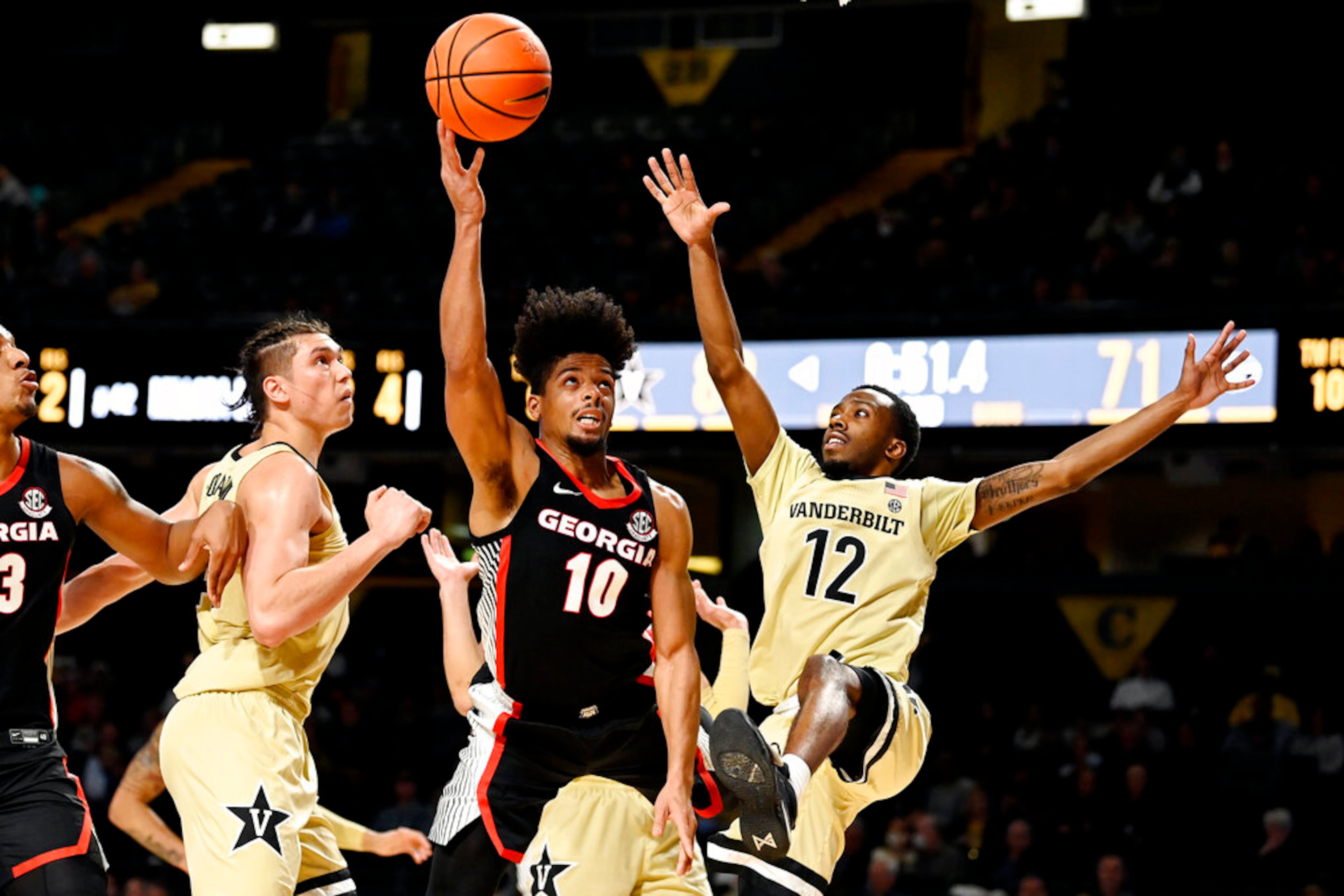 Georgia guard Aaron Cook (10) drives between Vanderbilt forward Quentin Millora-Brown, second from left, and guard Trey Thomas (12) during the second half. (AP Photo/Mark Zaleski)