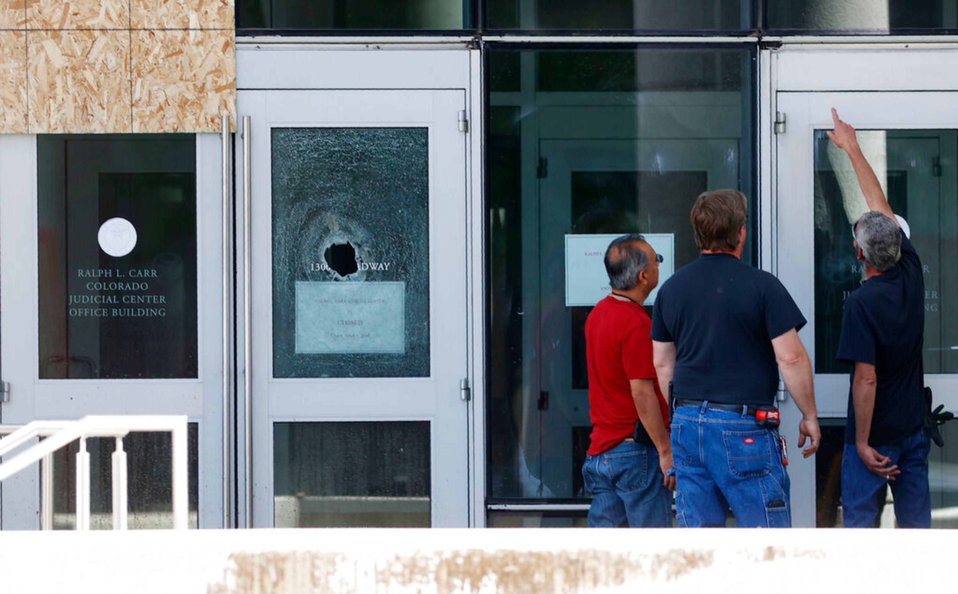 Workers assess damge to the doors and windows of the Colorado Supreme Court building after rioting over the death of George Floyd, a handcuffed black man in police custody in Minneapolis, Sunday, May 31, 2020, in Denver. (AP Photo/David Zalubowski)