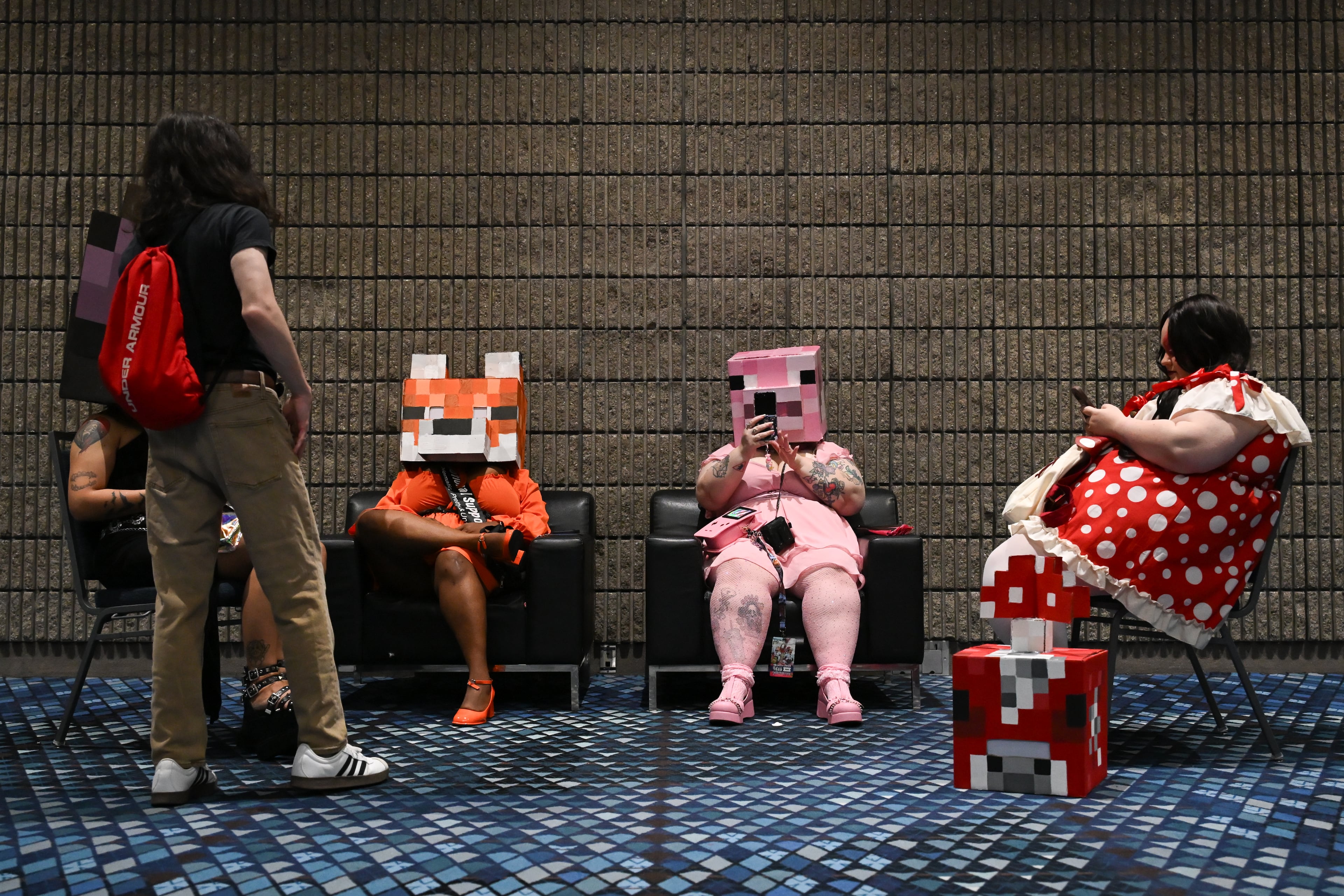 Attendees, dressed as characters from Minecraft, take a break during MomoCon at the Georgia World Congress Center in Atlanta on Friday, May 22, 2026. (Tyler Sun for the AJC)
