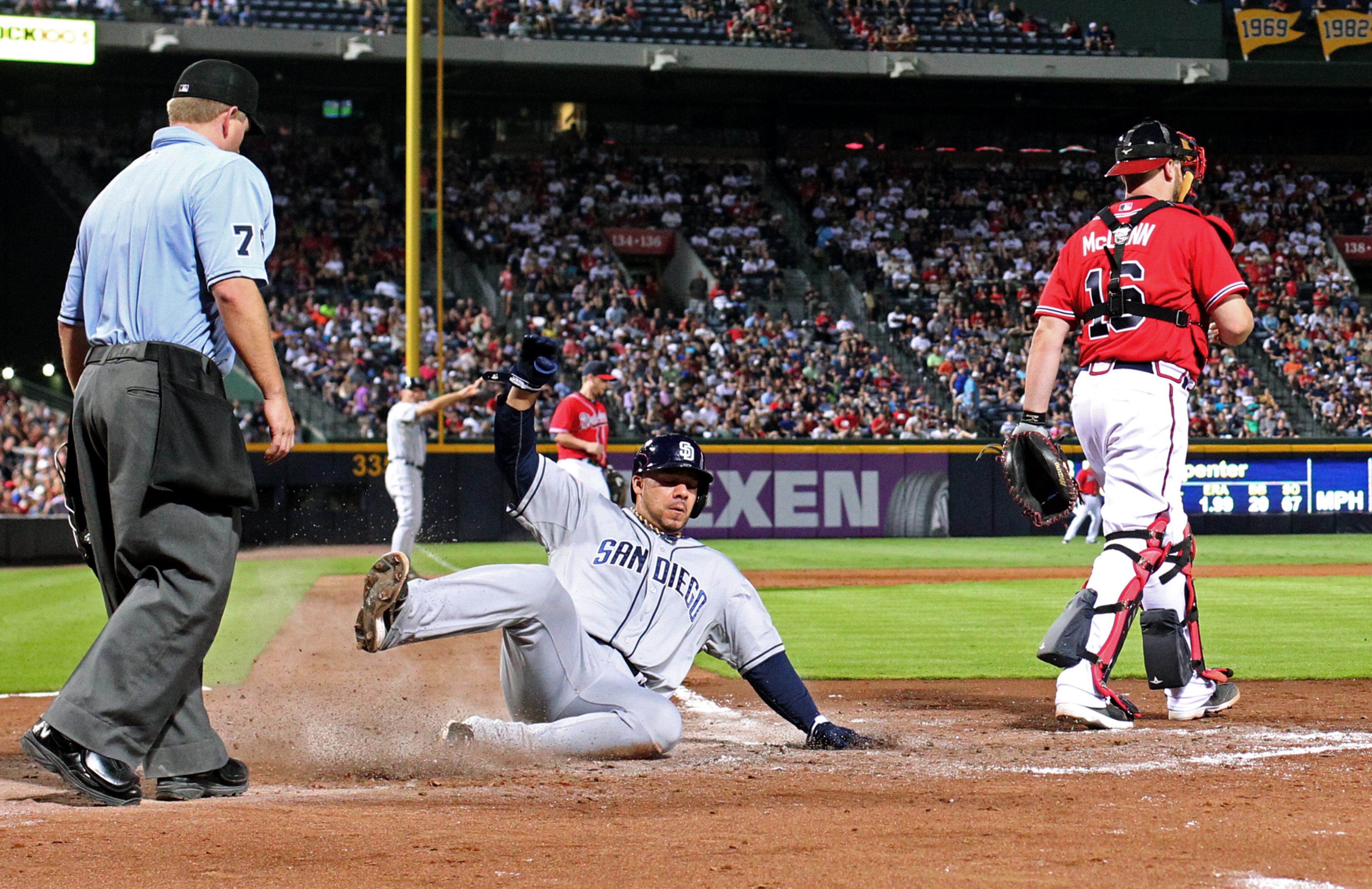 San Diego Padres catcher Rene Rivera scores on a sacrifice fly by Chris Denorfia as Atlanta Braves catcher Brian McCann is shown on the play in the 7th inning of their game at Turner Field Friday night in Atlanta, Ga., September 13, 2013. The San Diego Padres won 4-3 over the Atlanta Braves. JASON GETZ / JGETZ@AJC.COM