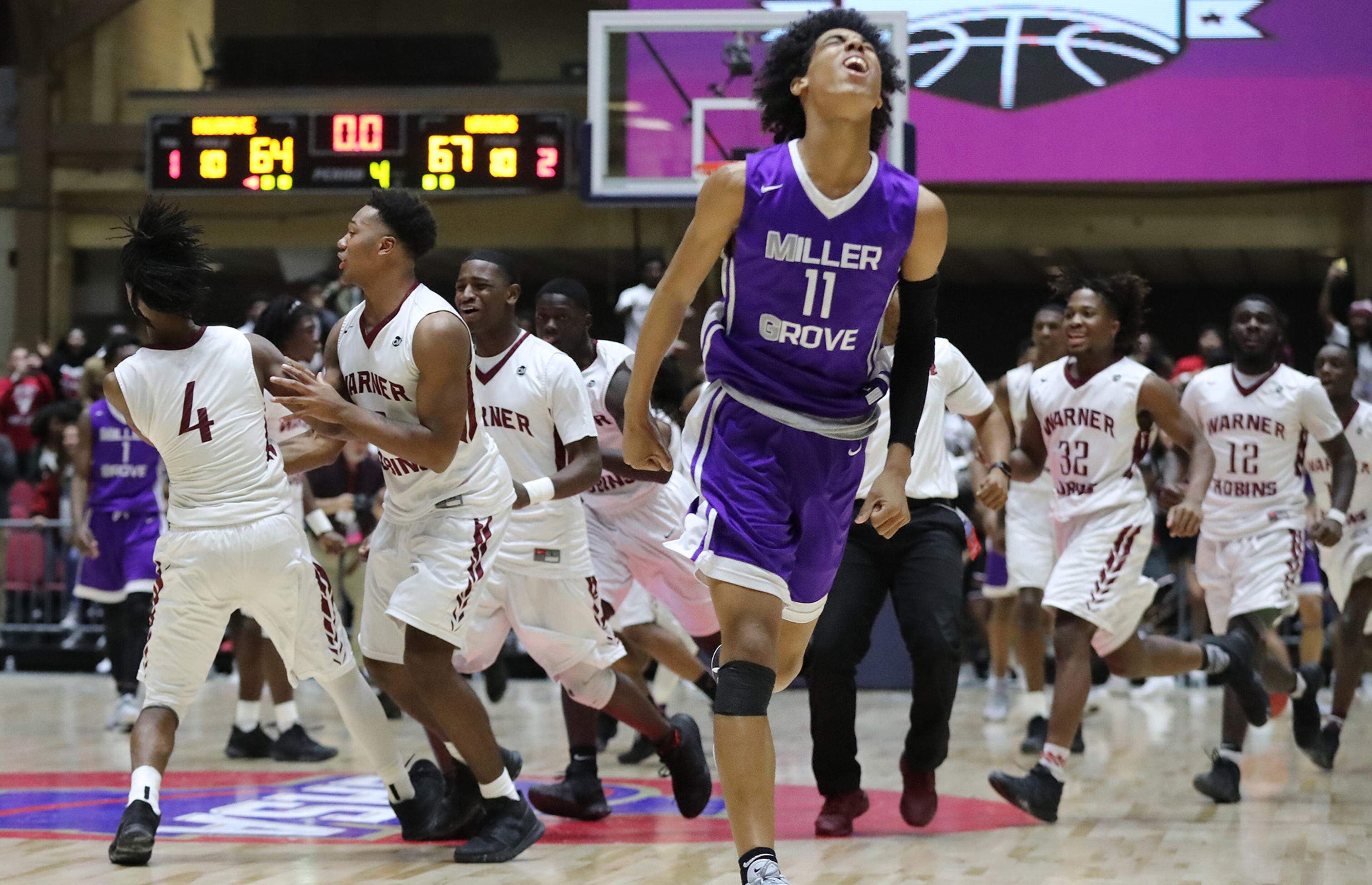 Miller Grove guard Terrence Edwards reacts after Warner Robins guard (4) Jacolbey Owens hits a three point shot in the final seconds for a 67-64 victory and is mobbed by teammates in their GHSA state basketball championship game on Thursday, March 8, 2018, in Macon. Curtis Compton/ccompton@ajc.com
