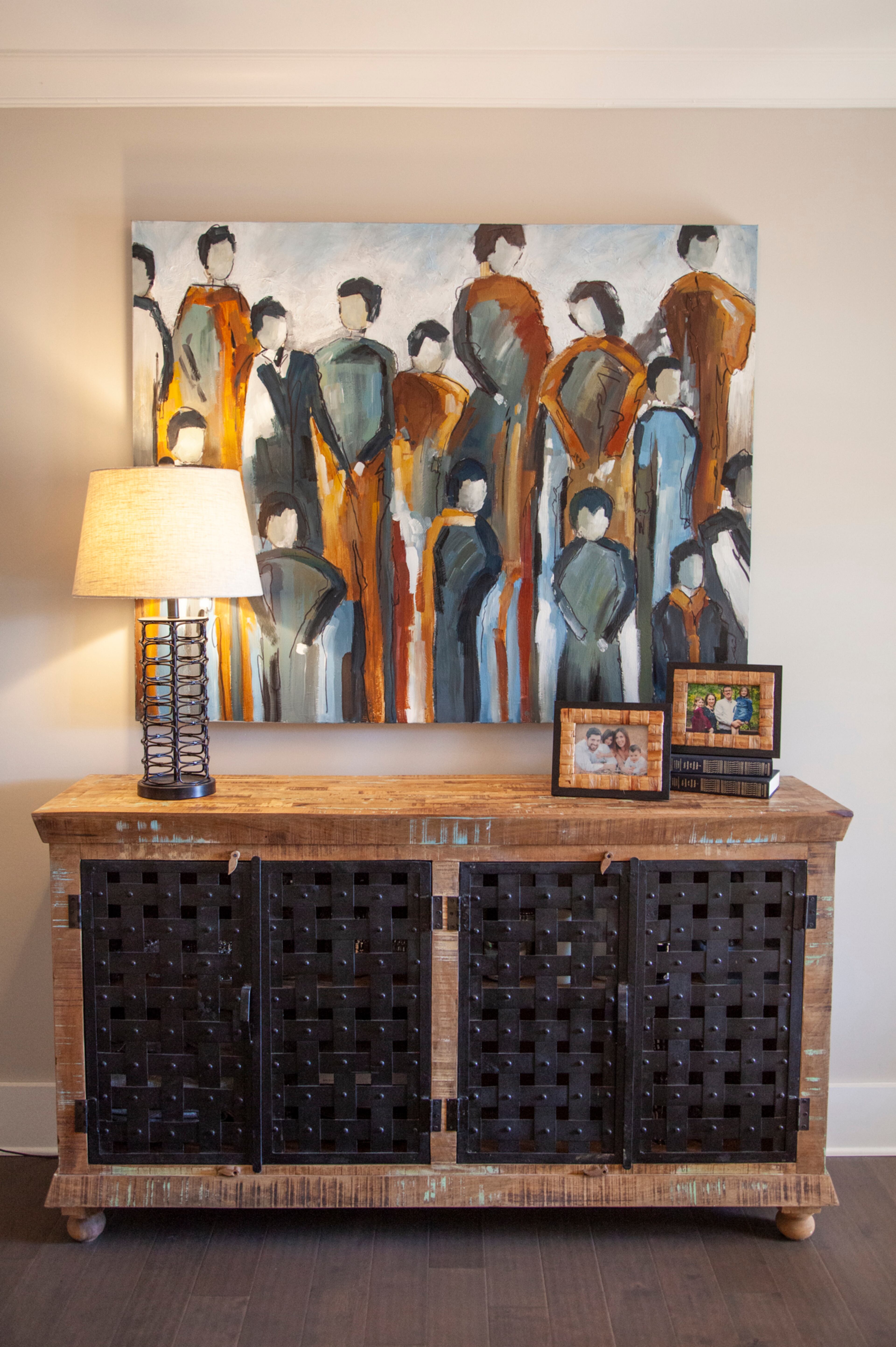 In the entryway, a painting that the family dubbed "the choir" hangs above a sideboard with metal lattice work.