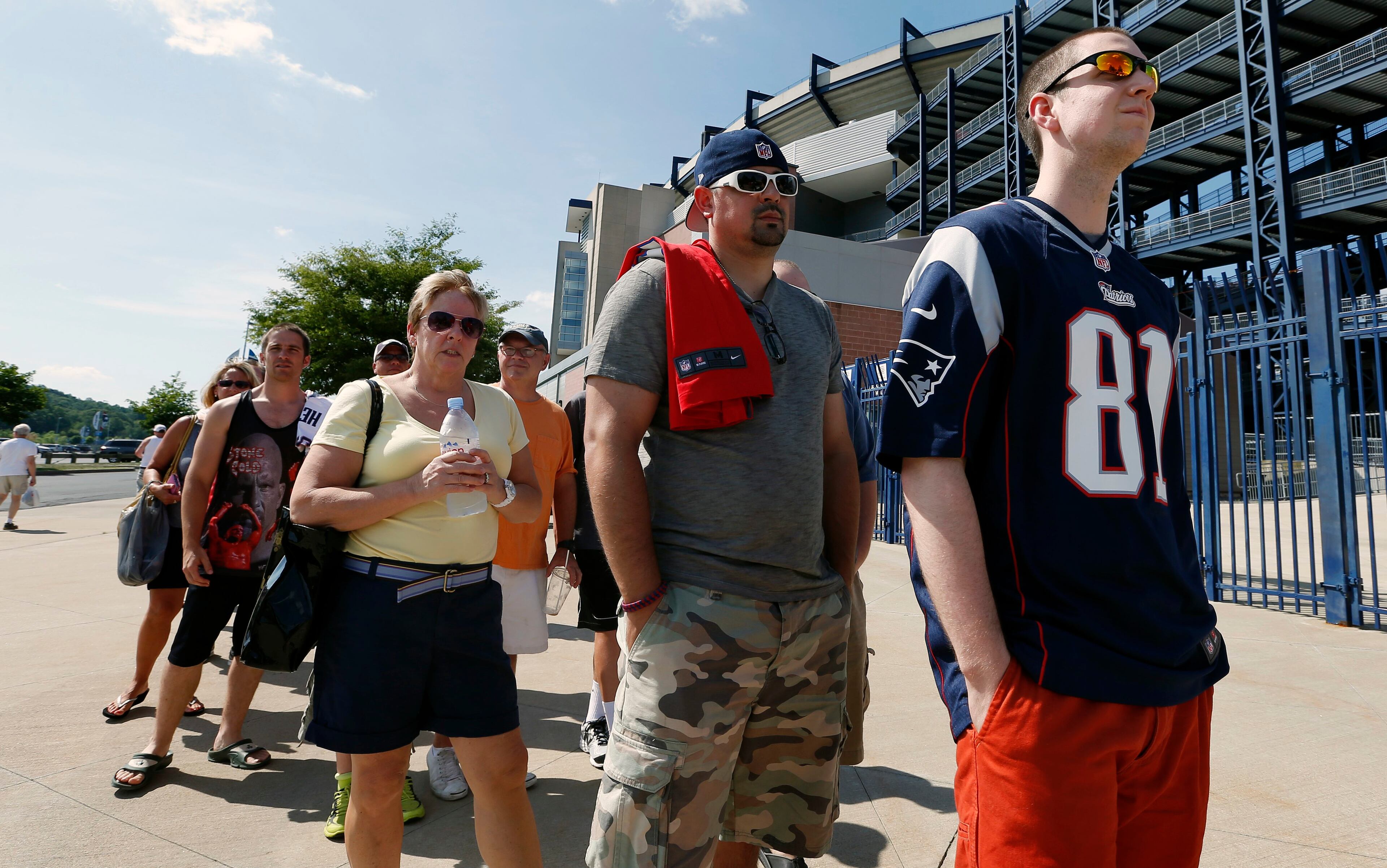 Mike Davies, right, of Norfolk, Mass., wears his New England Patriots Aaron Hernandez football jersey one last time while waiting in an exchange line outside Gillette Stadium in Foxborough, Mass., Saturday, July 6, 2013. Fans may trade an Aaron Hernandez jersey with his name on it they purchased for one of another player on the NFL team. The team released Hernandez after he was arrested for allegedly orchestrating the death of Odin Lloyd. (AP Photo/Michael Dwyer)