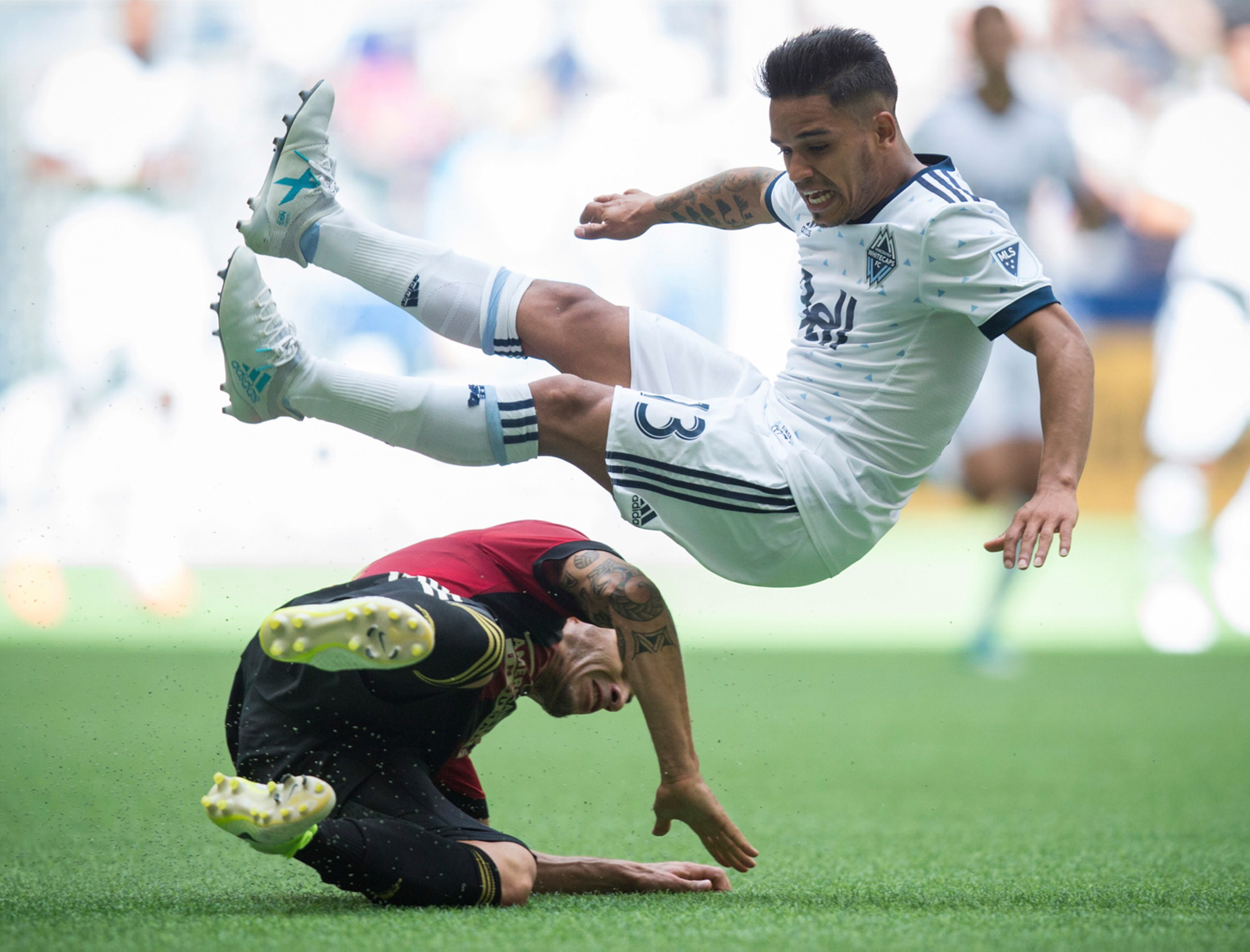 Vancouver Whitecaps' Cristian Techera, right, is upended by Atlanta United's Carlos Carmona during the second half of an MLS soccer match Saturday, June 3, 2017, in Vancouver, British Columbia. (Darryl Dyck/The Canadian Press via AP)