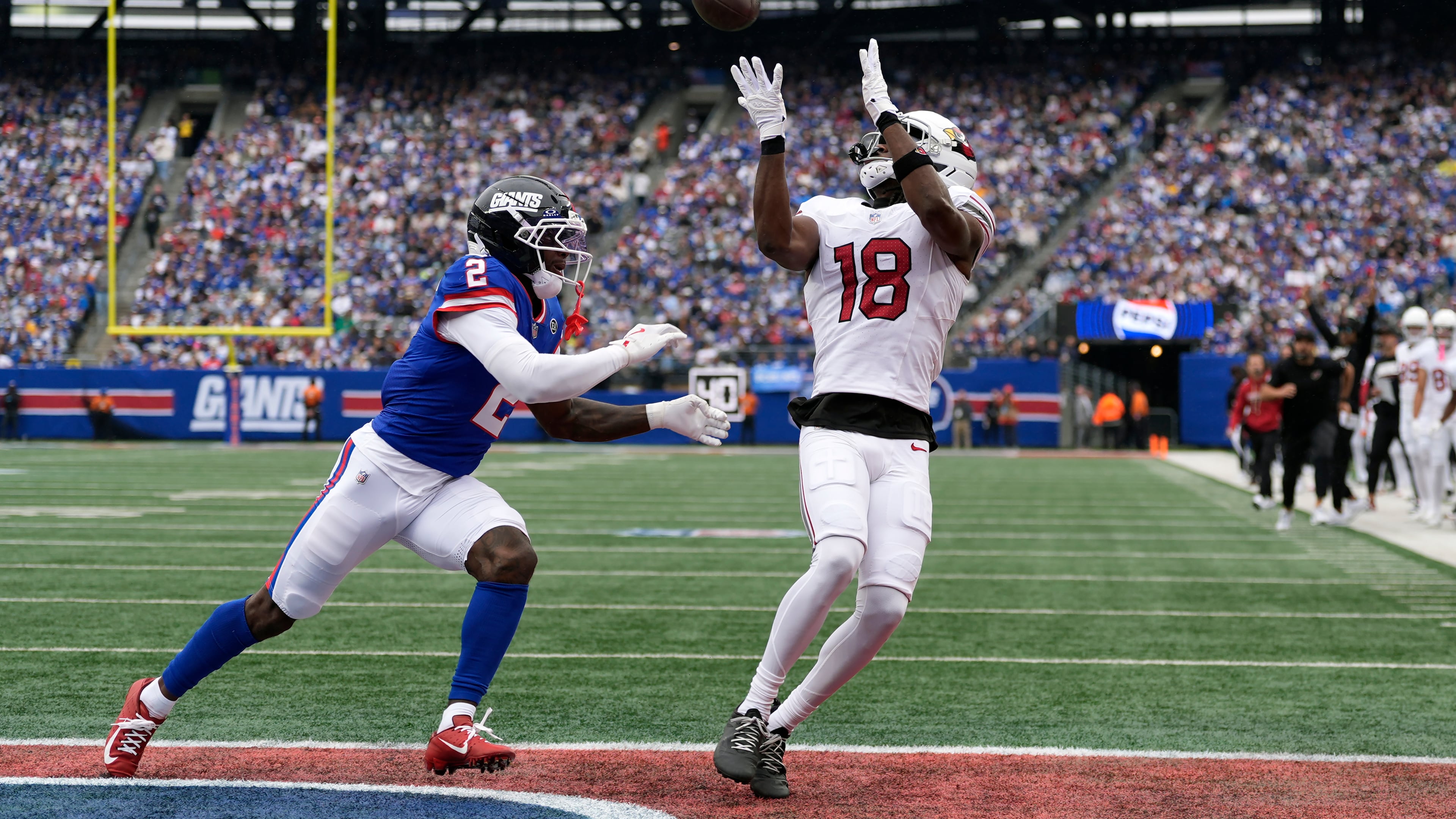 Arizona Cardinals wide receiver Marvin Harrison Jr. (18) makes a touchdown catch against New York Giants cornerback Deonte Banks (2) during an NFL football game, in East Rutherford, N.J., Sunday, Oct. 4, 2026. (AP Photo/Seth Wenig)