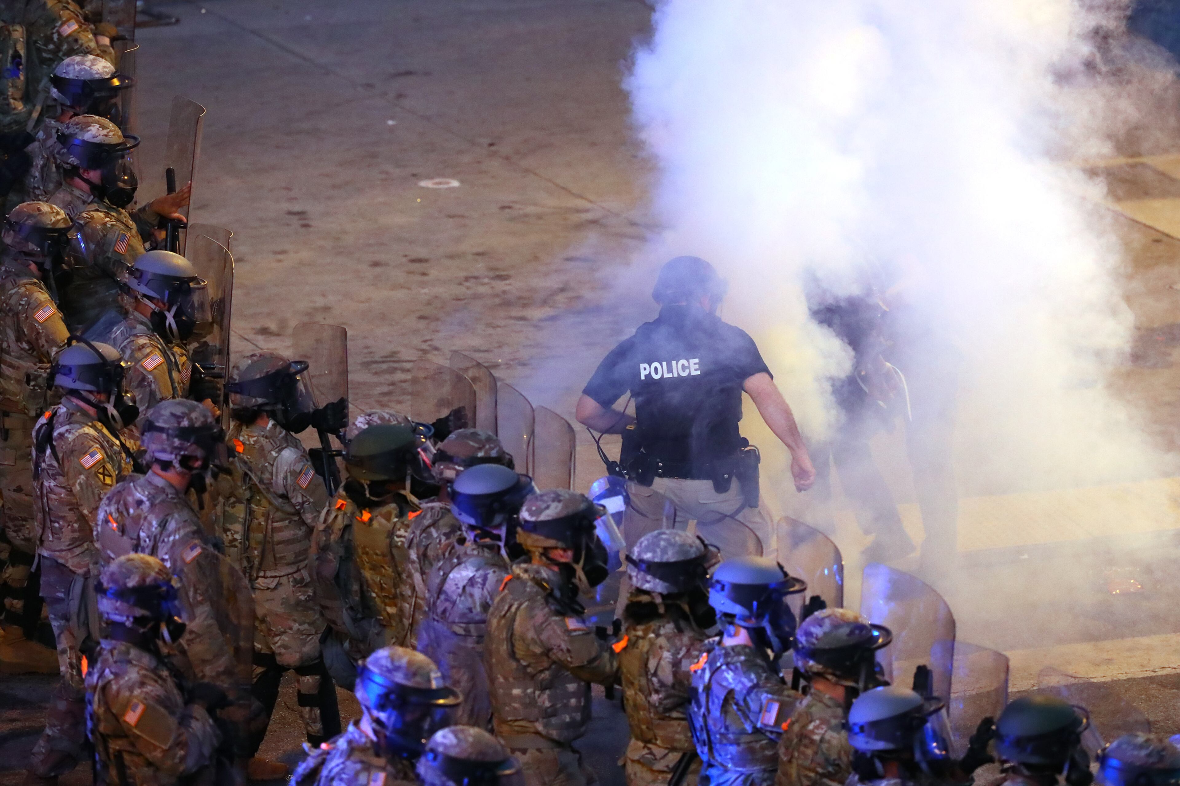 060220 Atlanta: Georgia Army National Guard soldiers advance on protesters through tear gas on Centennial Olympic Park Drive outside the CNN Center at Olympic Park after curfew during a fifth day of protests over the death of George Floyd on Tuesday, June 2, 2020, in Atlanta. Curtis Compton ccompton@ajc.com