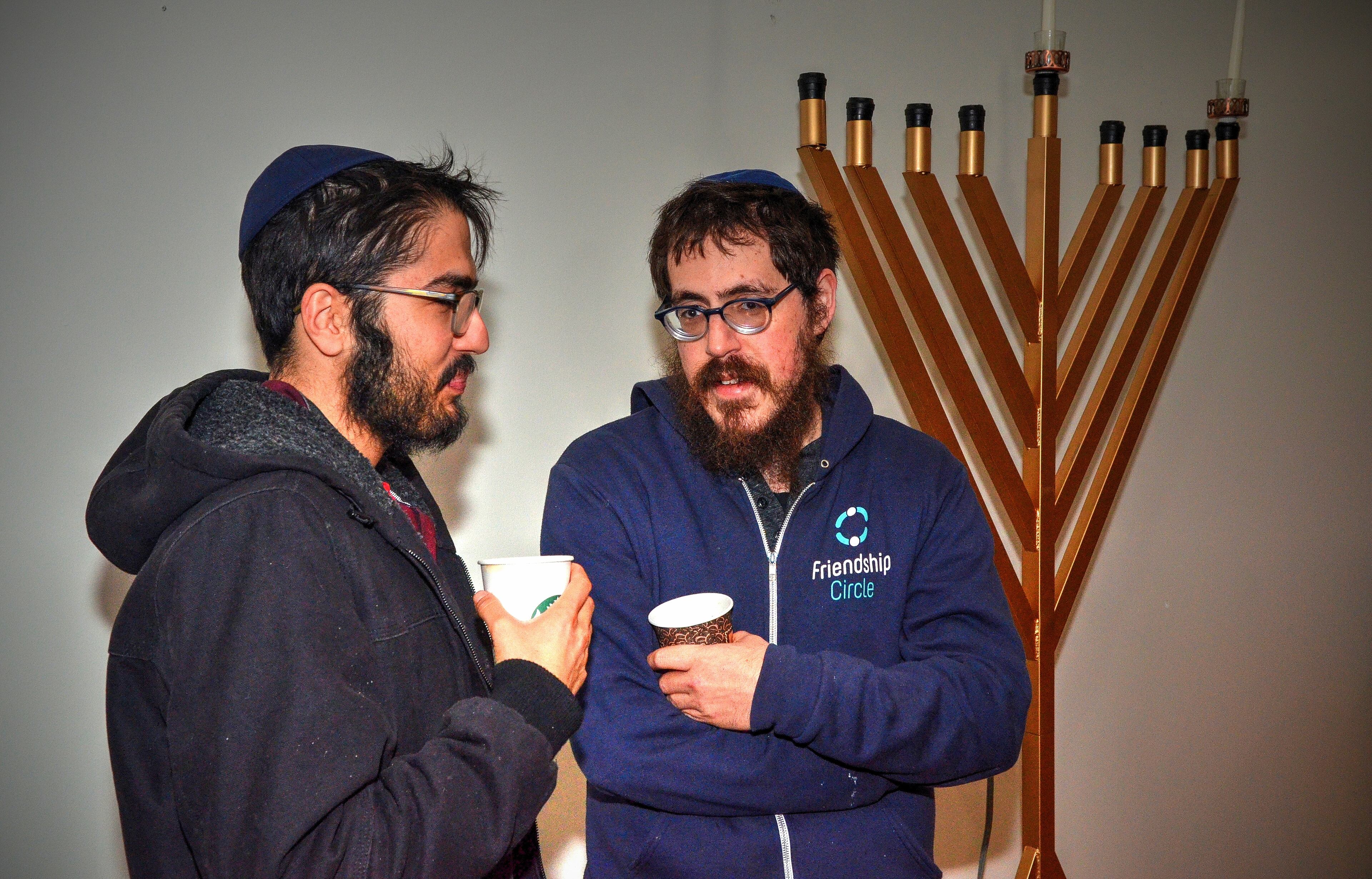 191222 Atlanta, Ga: Ariel Steinberg (left) and Mendel Groner have a chat before the menorah lighting ceremony. Menorah lighting and celebration sponsored by Chabad Intown and MJCAA Day Camps. Music, entertainment, Dreidels, doughnuts, hot latkes, gelt drop and more. Children who RSVP will recieve and Chanukah gift. All photos taken Sunday 12/22/2019 at Chabad Intown, along the Beltline in Atlanta, Ga. (Photo credit Chris Hunt Photography) for 122319hanukkah
