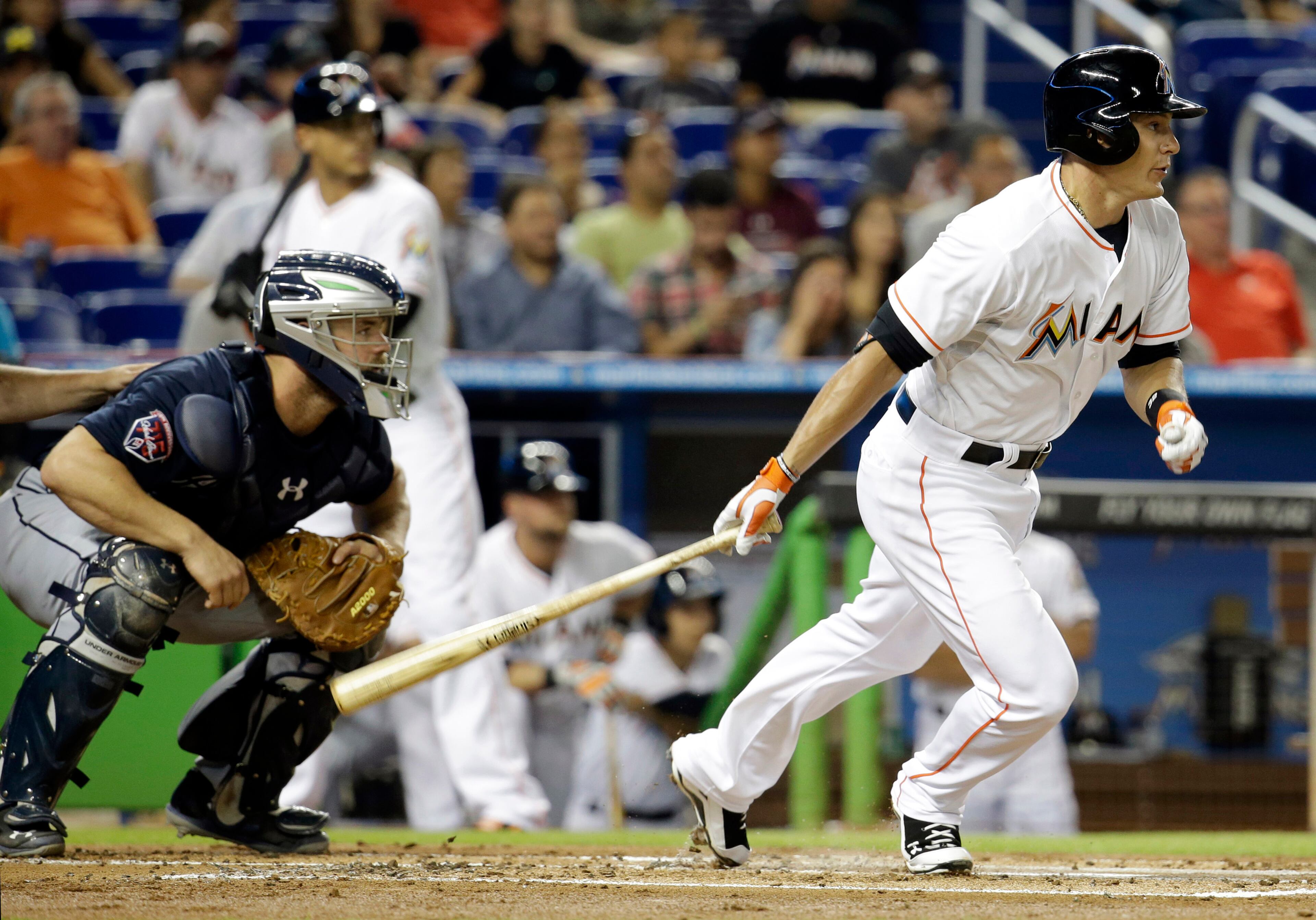 Miami Marlins' Derek Dietrich, right, watches after hitting a single in the first inning of a baseball game against the Atlanta Braves, Thursday, May 1, 2014, in Miami. Braves catcher Evan Gattis, left, looks on. (AP Photo/Lynne Sladky)