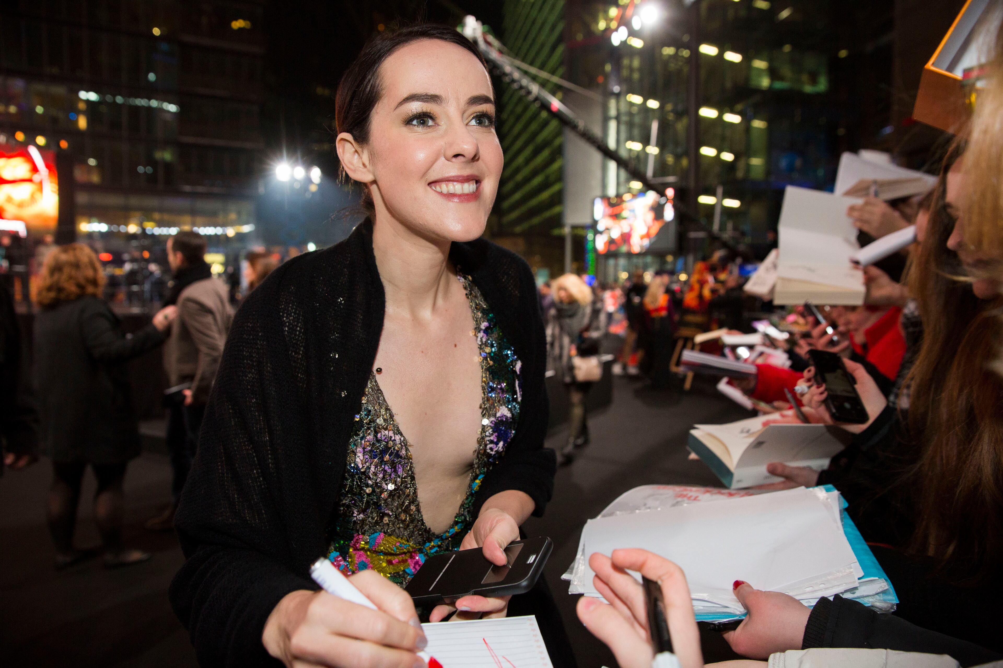 US actress Jena Malone signs autographs before the world premiere of the movie "The Hunger Games: Mockingjay - Part 2" in Berlin, Germany, Wednesday, Nov. 4, 2015. (AP Photo/Gero Breloer)