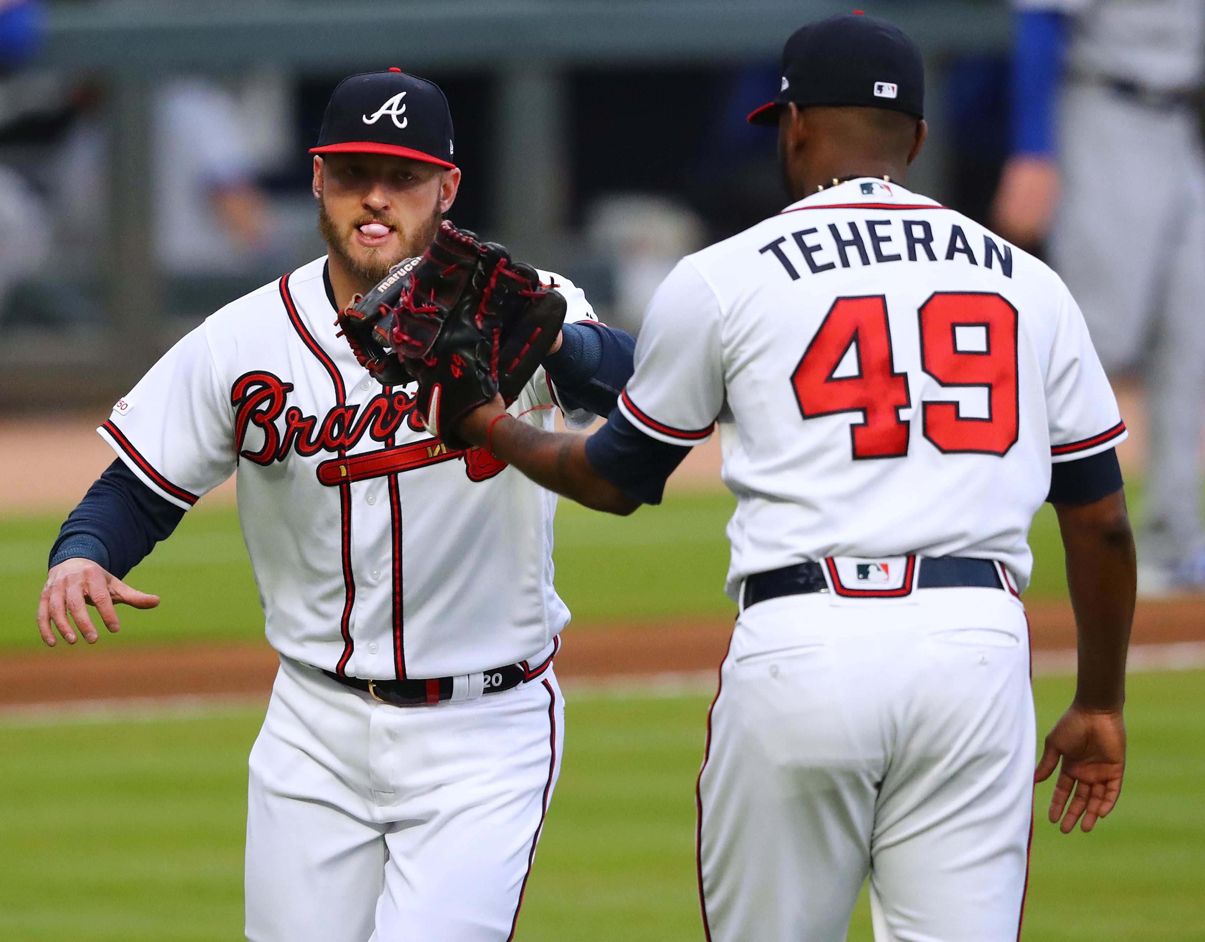 Braves pitcher Julio Teheran gives third baseman Josh Donaldson five after he helped turn a double play. Curtis Compton/ccompton@ajc.com