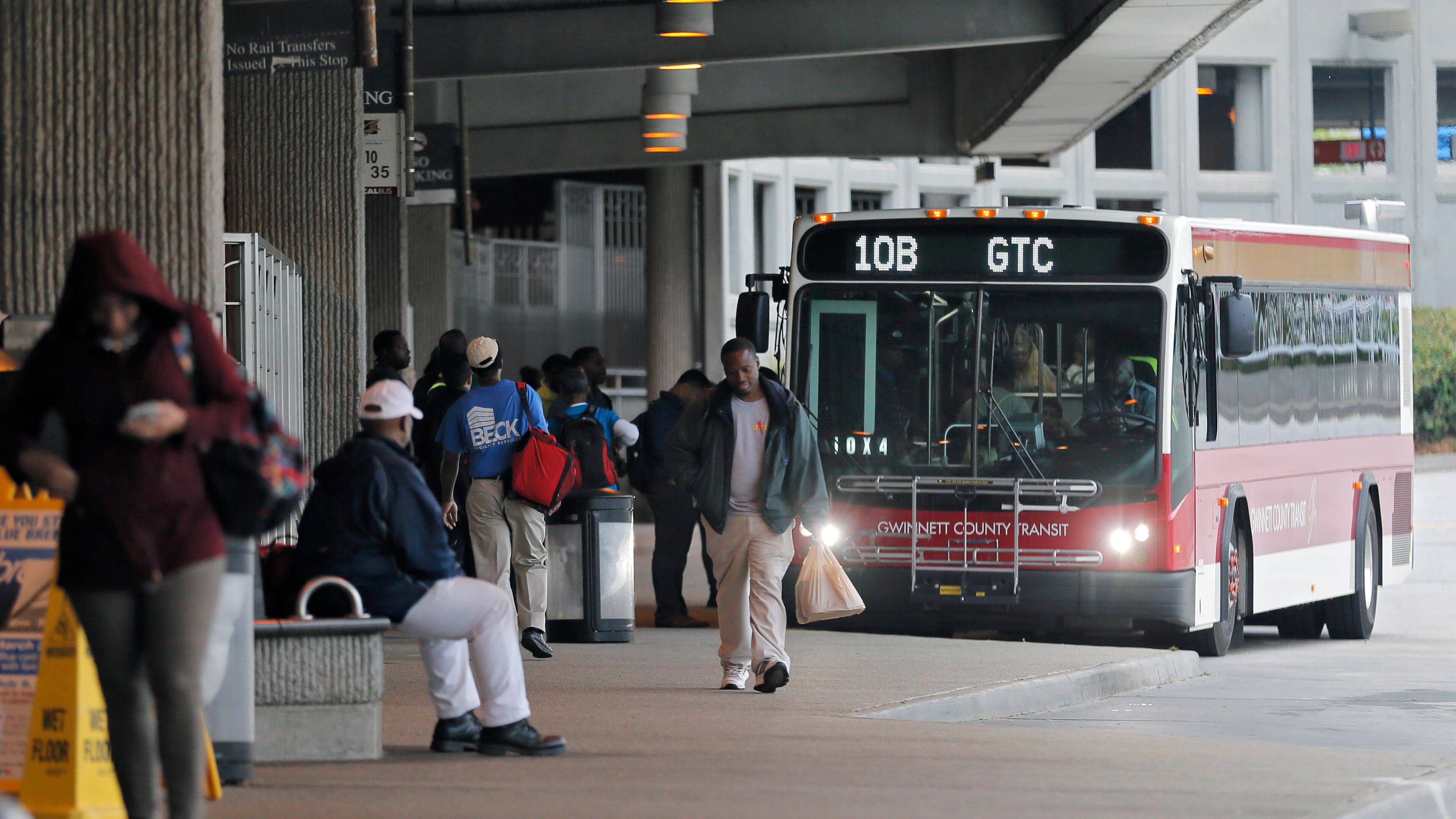 Passengers board a Gwinnett County Transit bus at the Doraville MARTA station in April. BOB ANDRES /BANDRES@AJC.COM