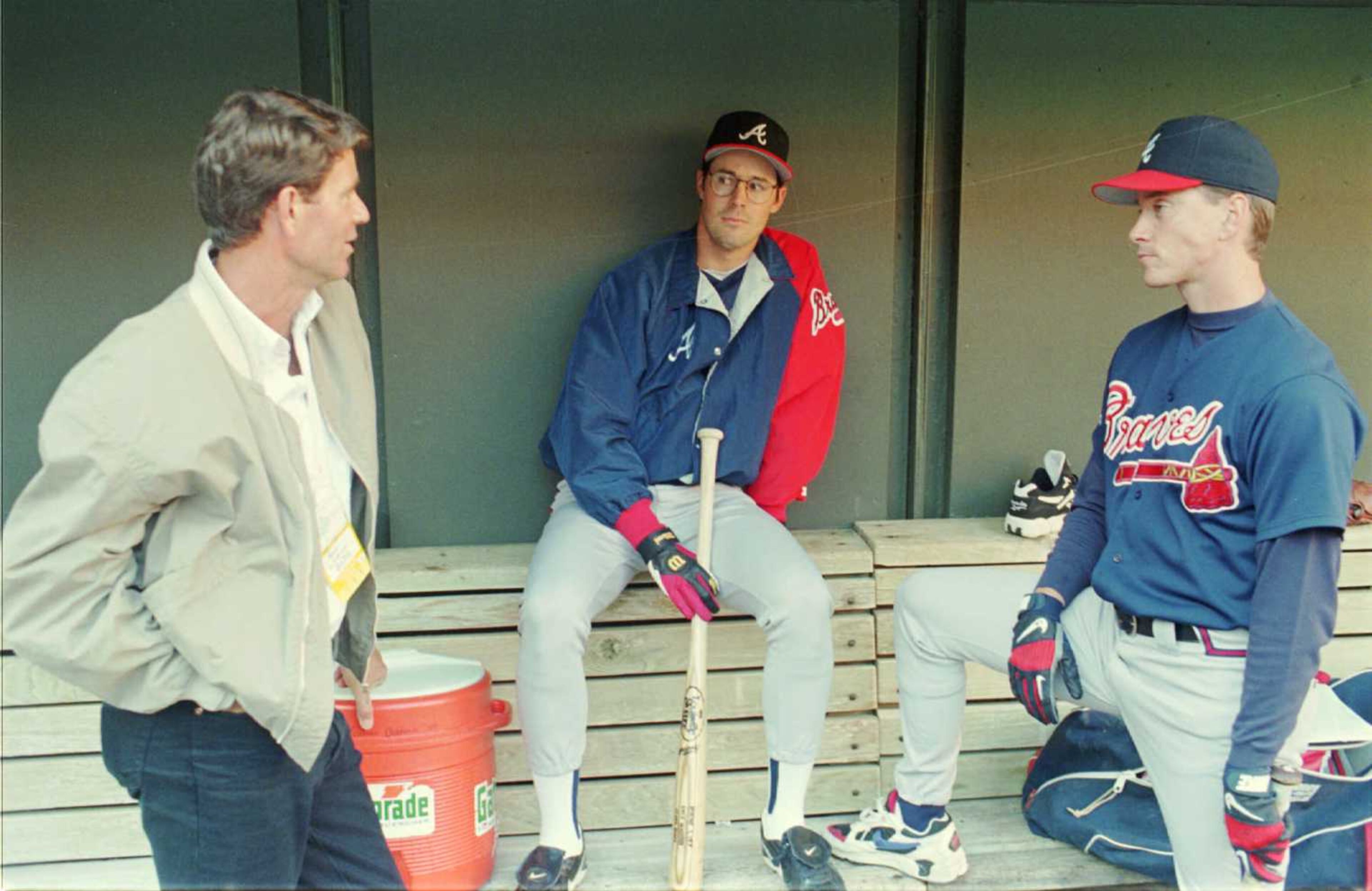 Three-time Cy Young award winner Jim Palmer (left) talks with Braves pitcher Greg Maddux (center) and Tom Glavine in the dugout.