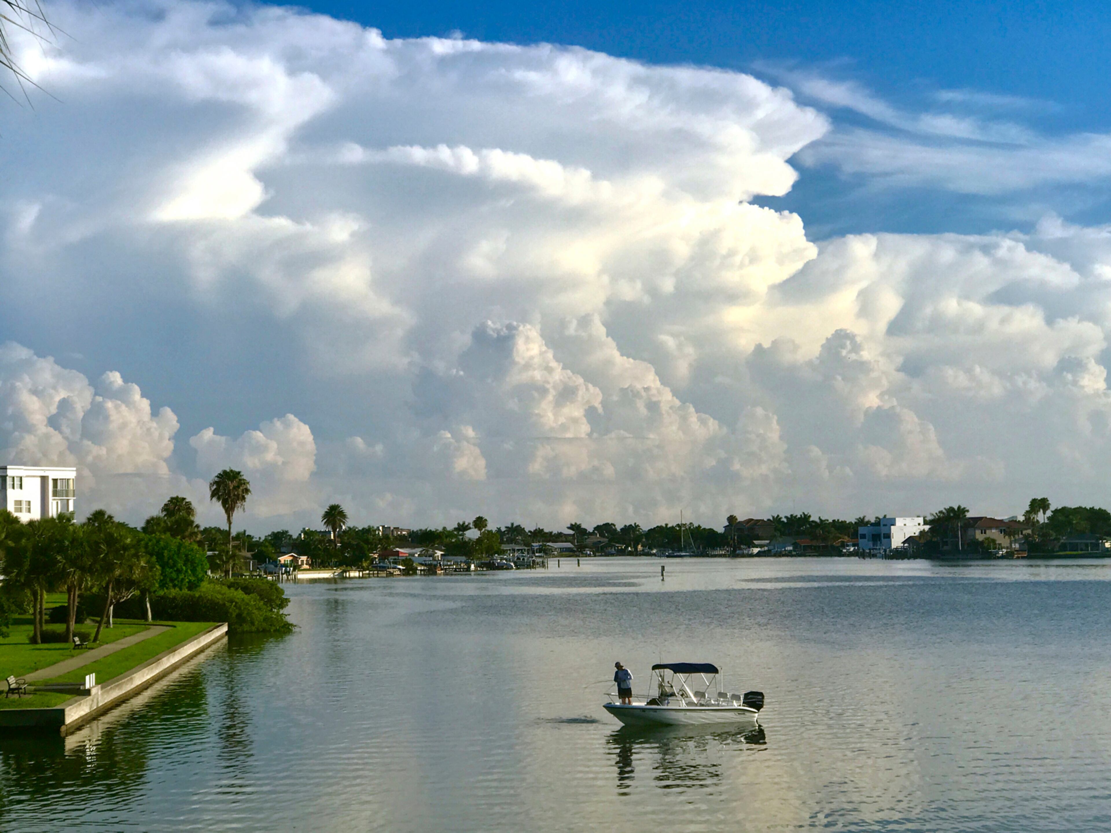 A fisherman tries his luck on the waters of Boca Ceiga Bay, taken from South Pasadena, Fla., Monday, July 3, 2017, as thunderstorms move along the coast of Pasco and Hernando Counties, north of Pinellas County. Spotty storms are in the forecast in the Tampa Bay region for the Fourth of July and the rest of the week. (Scott Keeler/Tampa Bay Times via AP)