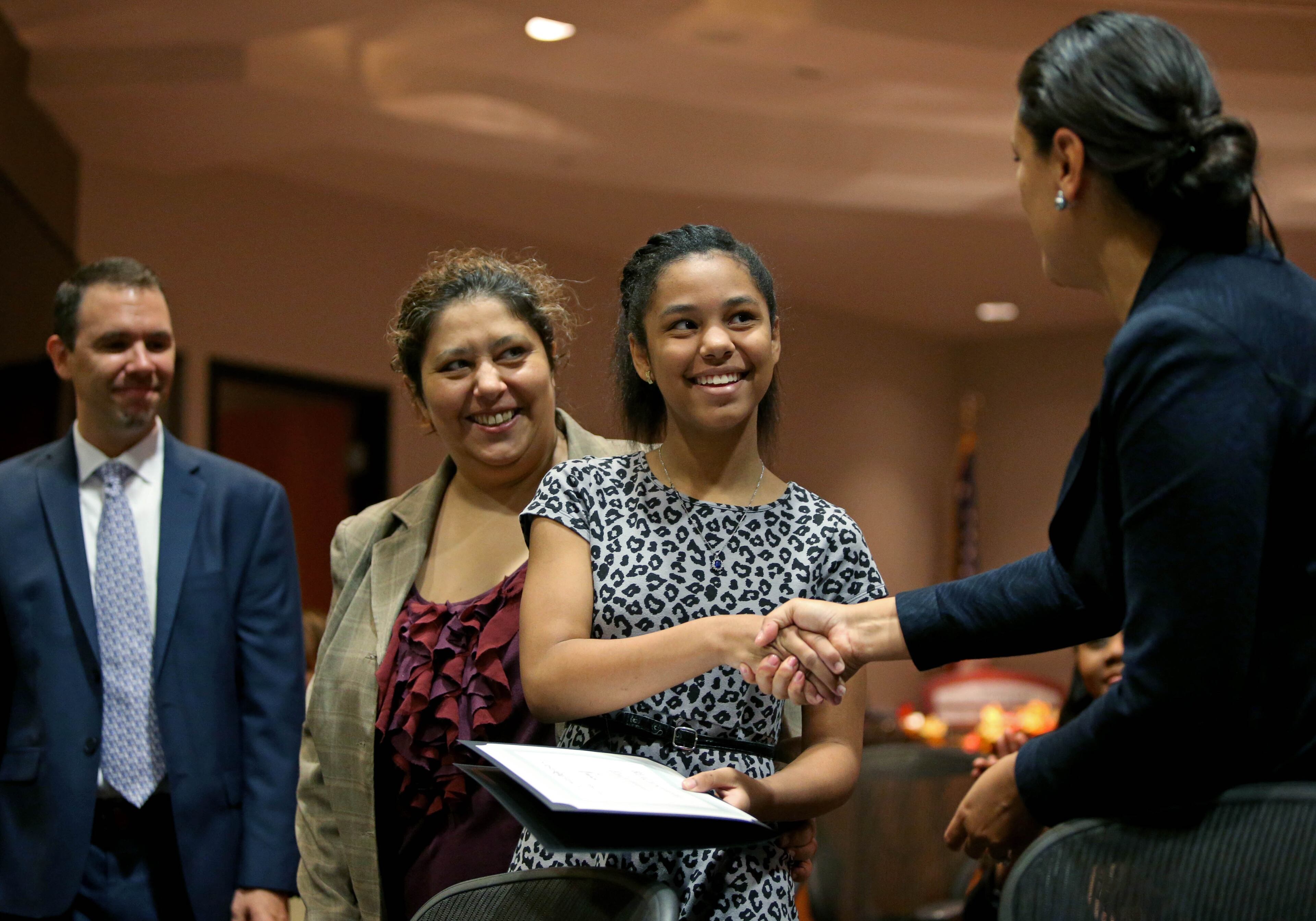 Emily Weaver, a student at Crawford W. Long Middle, center, greets Atlanta Public Schools Superintendent Meria J. Carstarphen, right, after she participated in the REACH Statewide Signing Day at the Atlanta Public Schools headquarters Wednesday morning in Atlanta, Ga., September 24, 2014. Also pictured is Emily's mother Marcela Weaver, left. 16 students at APS received the REACH scholarship.