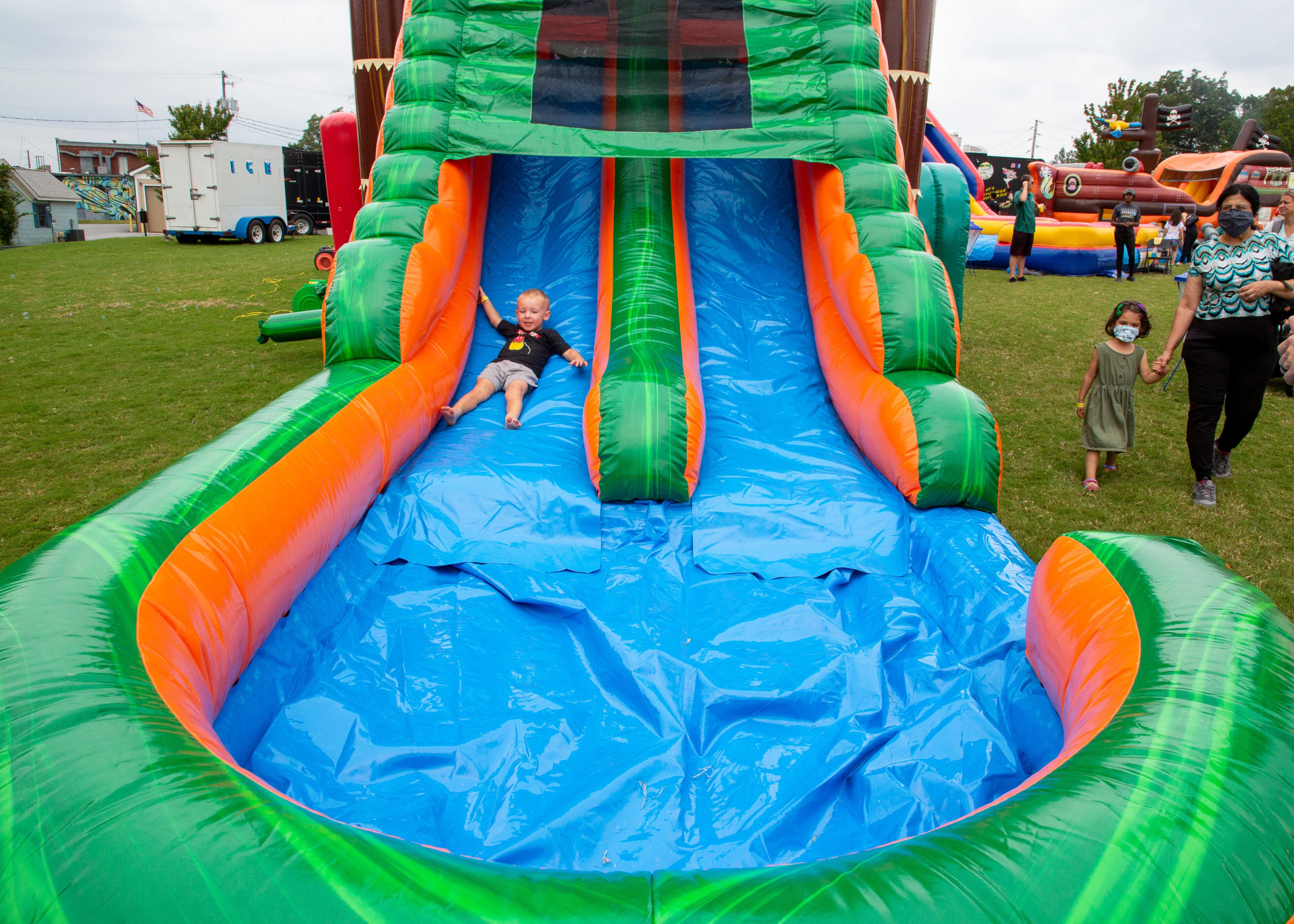 Matthew Courteney, 2, slides down one of the rides at the Norcross Art Splash Festival on Sunday, October 3, 2021. Interactive fun for kids was also available in addition to artwork and festival food. (Photo: Steve Schaefer for The Atlanta Journal-Constitution)