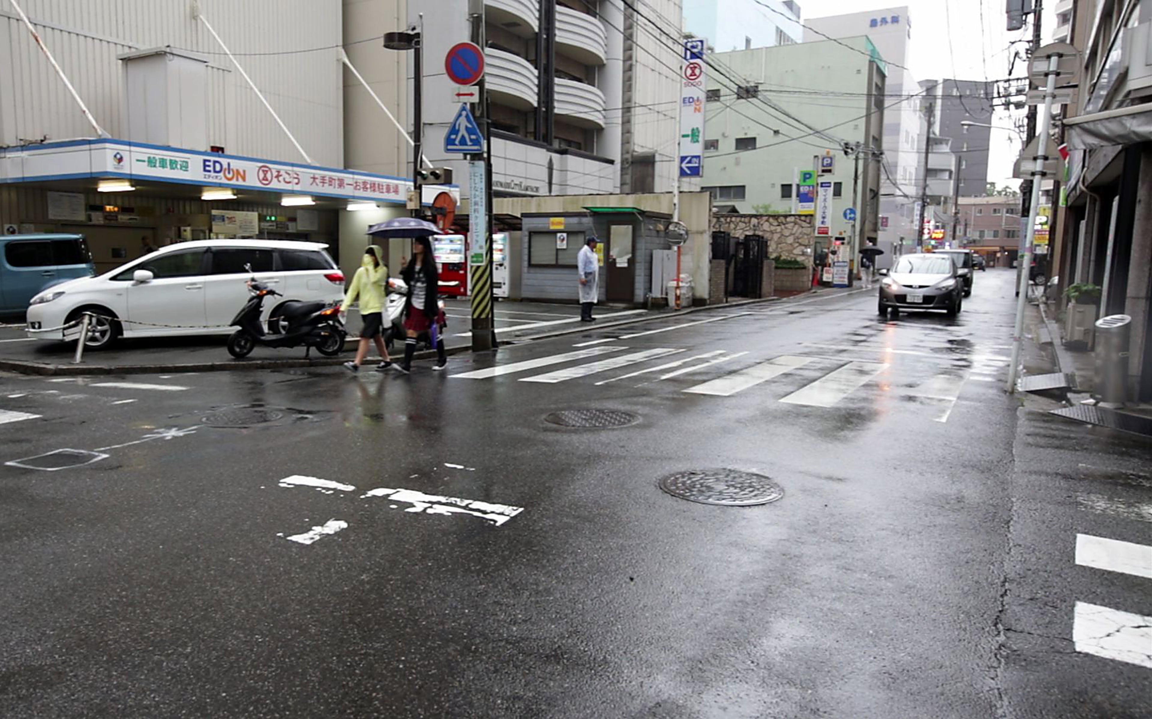 In this July 4, 2015 photo, two persons walk in the rain near the ground zero of 1945 A-Bomb, near now known as Atomic Bomb Dome in Hiroshima, western Japan. On Aug. 6, 1945, a U.S. plane dropped an atomic bomb on Hiroshima, the first nuclear weapon has been used in war. Japan surrendered on Aug. 15, ending World War II. (AP Photo/Eugene Hoshiko)