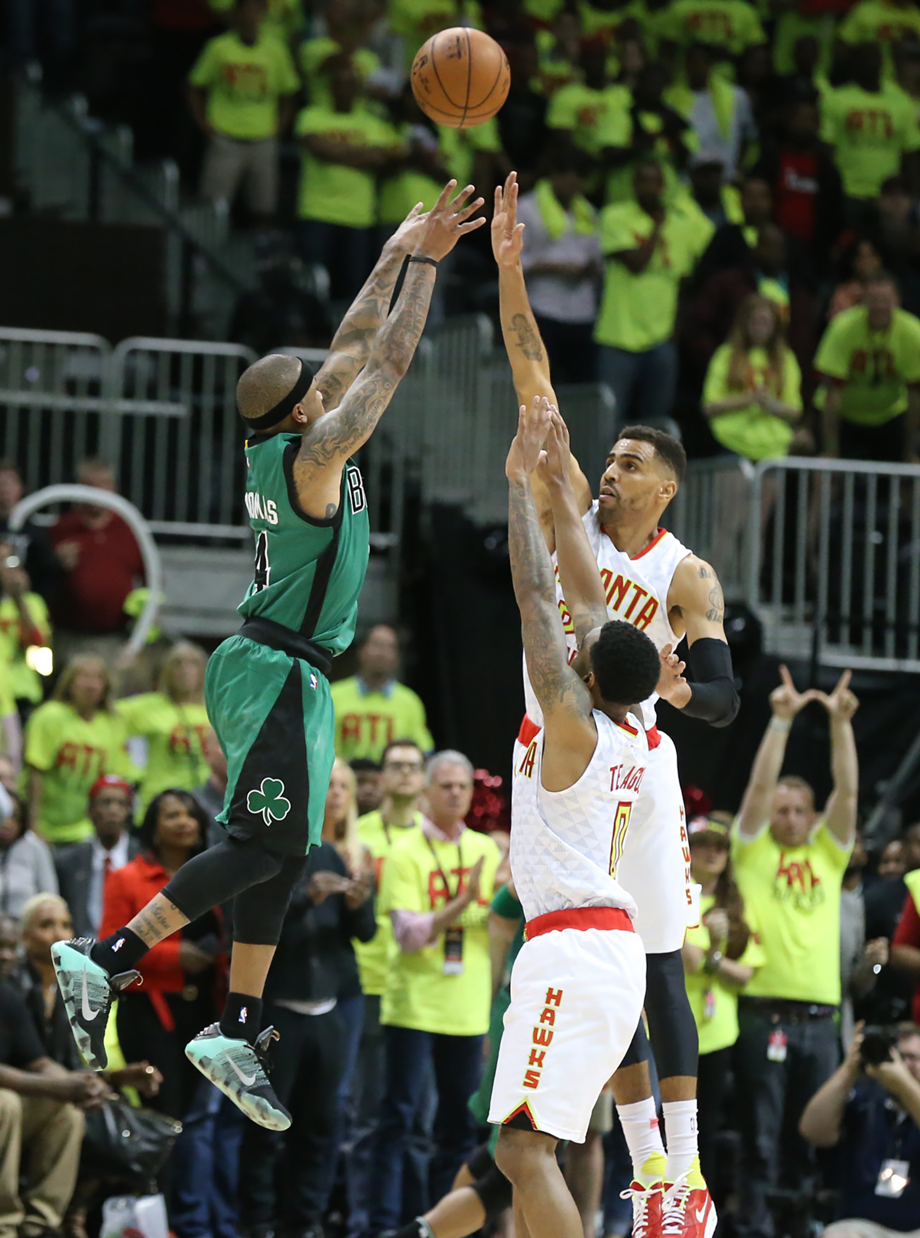 041616 ATLANTA: Celtics guard Isaiah Thomas makes it a one point game hitting a three over Hawks defenders Thabo Sefolosha and Jeff Teague in the final seconds of game one of their NBA Eastern Conference first round playoff game at Philips Arena on Saturday, April 16, 2016. The Hawks held on to win game one 102-101. Curtis Compton / ccompton@ajc.com