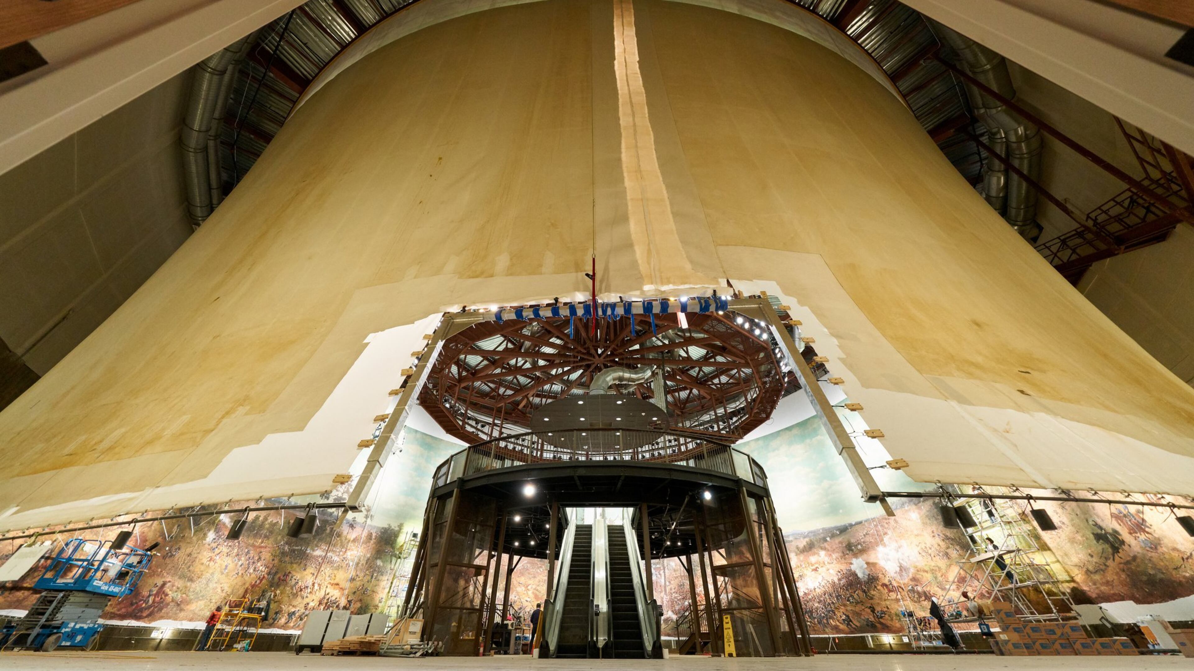 This photo shows an exterior view of the panoramic painting “The Battle of Atlanta” taken early in the restoration process. It reveals the hyperbolic shape of the painting when hung correctly. At the center is an escalator that will take visitors to the viewing platform. The diorama around the base of the painting had not yet been installed.CONTRIBUTED BY THE ATLANTA HISTORY CENTER