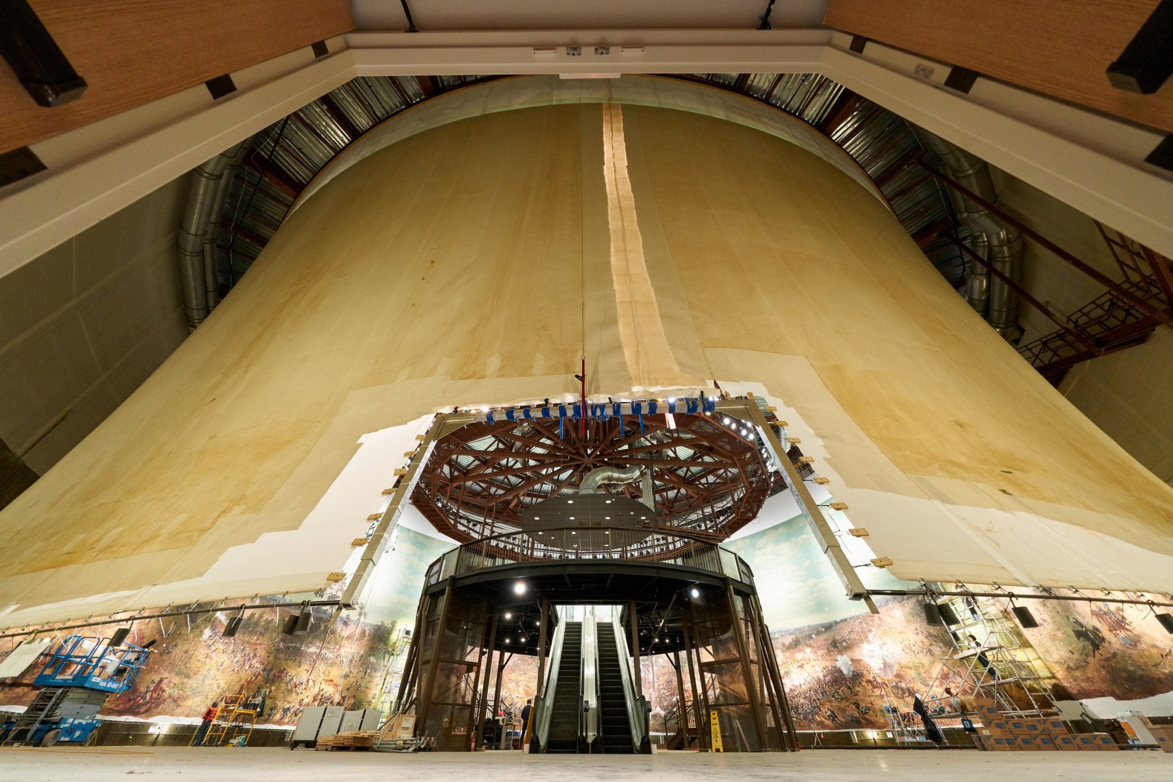 This shows an exterior view of the panoramic painting “The Battle of Atlanta” taken early in the restoration process. It reveals the hyperbolic shape of the painting when hung correctly. At the center is an escalator that will take visitors to the viewing platform. The diorama around the base of the painting had not yet been installed.CONTRIBUTED BY THE ATLANTA HISTORY CENTER