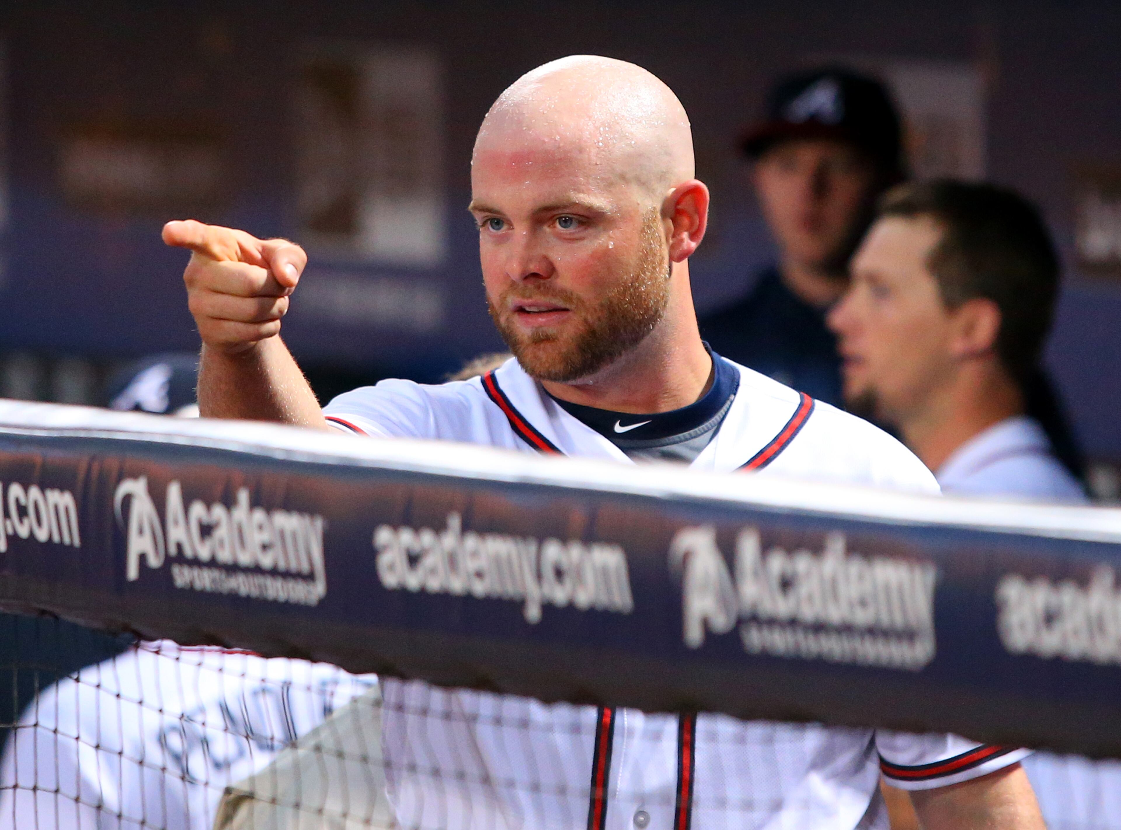 Atlanta Braves catcher Brian McCann points from the dugout at the Milwaukee Brewers dugout after his confrontation with Brewers batter Carlos Gomez following a home run by Gomez in the first inning of a baseball game Wednesday, Sept. 25, 2013 in Atlanta.