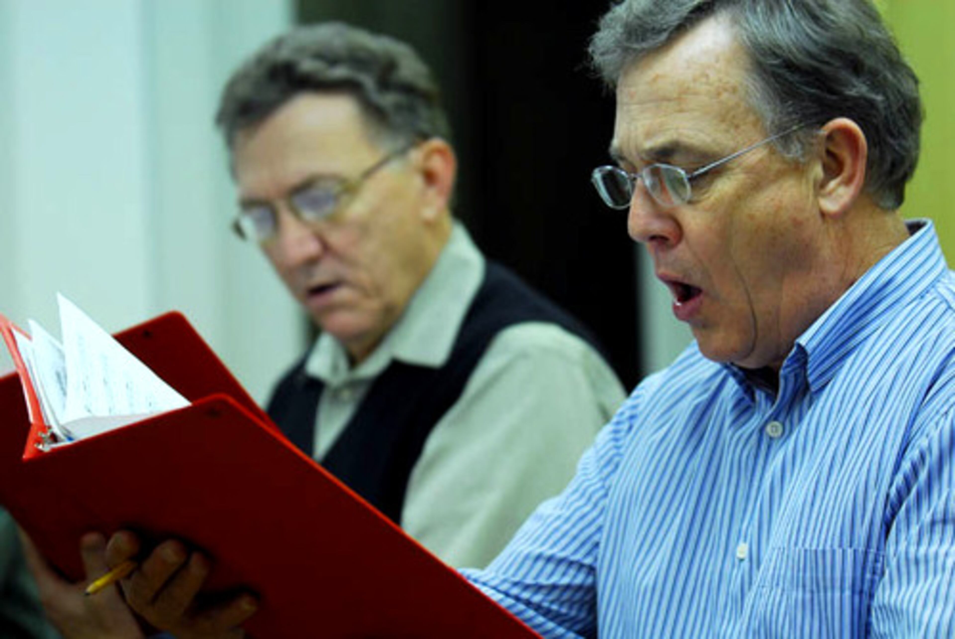 Geoff Walker (foreground) and Lee Morris, both from Atlanta, sing as tenors in the St. Dunstan's Episcopal church in Sandy Springs during a nighttime practice. The choir will debut an original choral piece called "In the Garden" by James Stevenson, on Palm Sunday, March 16.