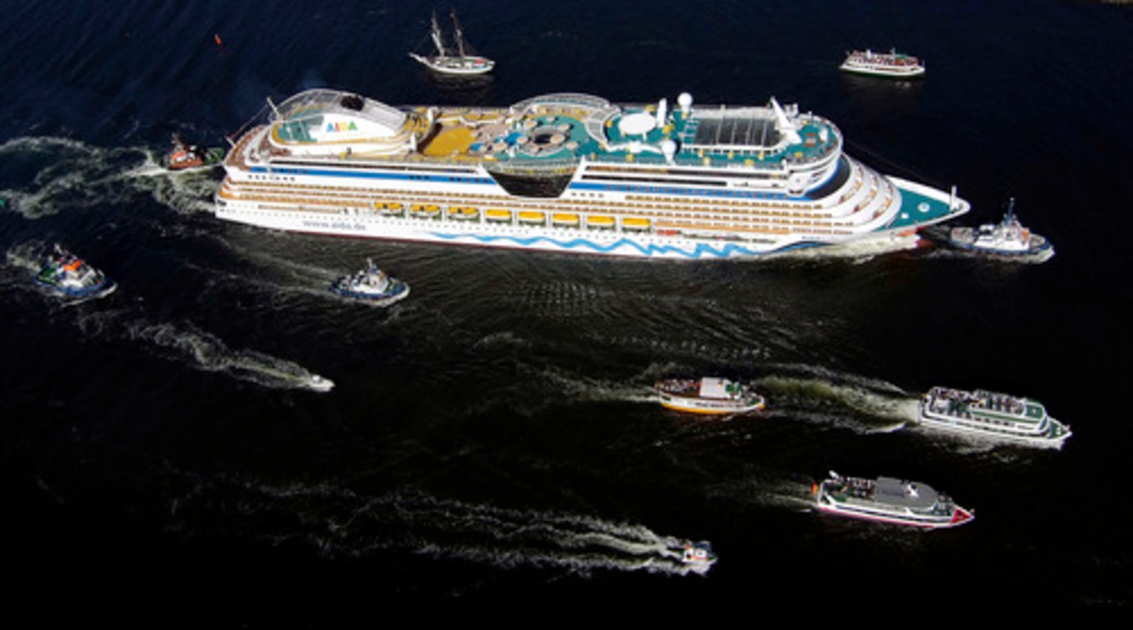 The new cruise liner AIDAbella is accompanied by smaller boats as it arrives at the cruise ship harbor in Warnemuende, Germany, on Monday. AIDA ships operate from German ports to Scandinavia and the Baltic.