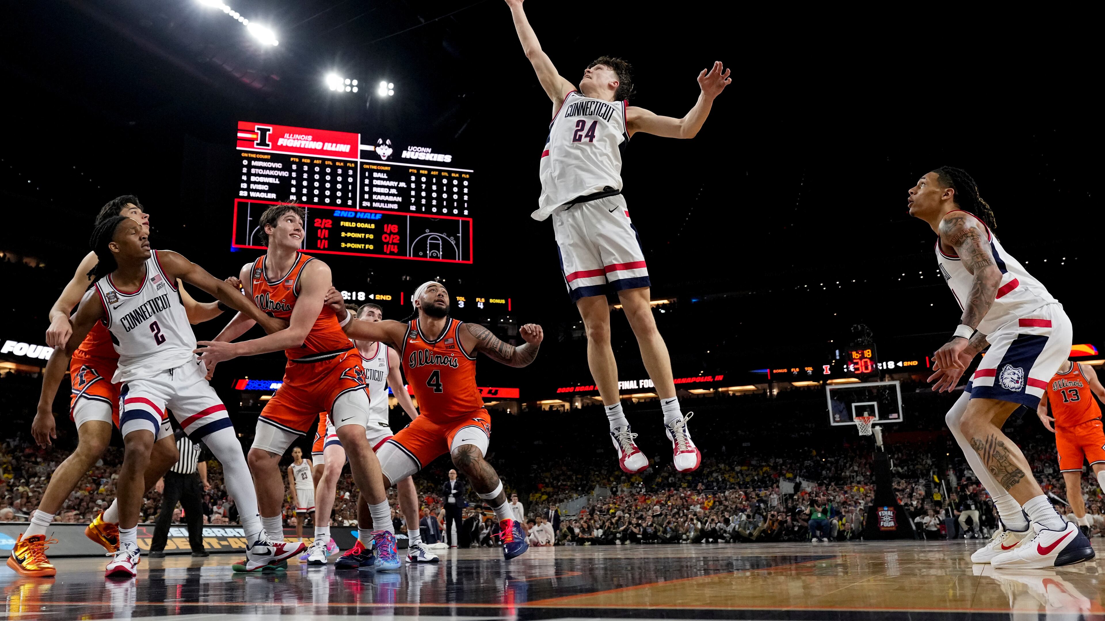 UConn guard Braylon Mullins (24) rebounds against Illinois during the second half of an NCAA college basketball tournament semifinal game at the Final Four, Saturday, April 4, 2026, in Indianapolis. (AP Photo/Abbie Parr)