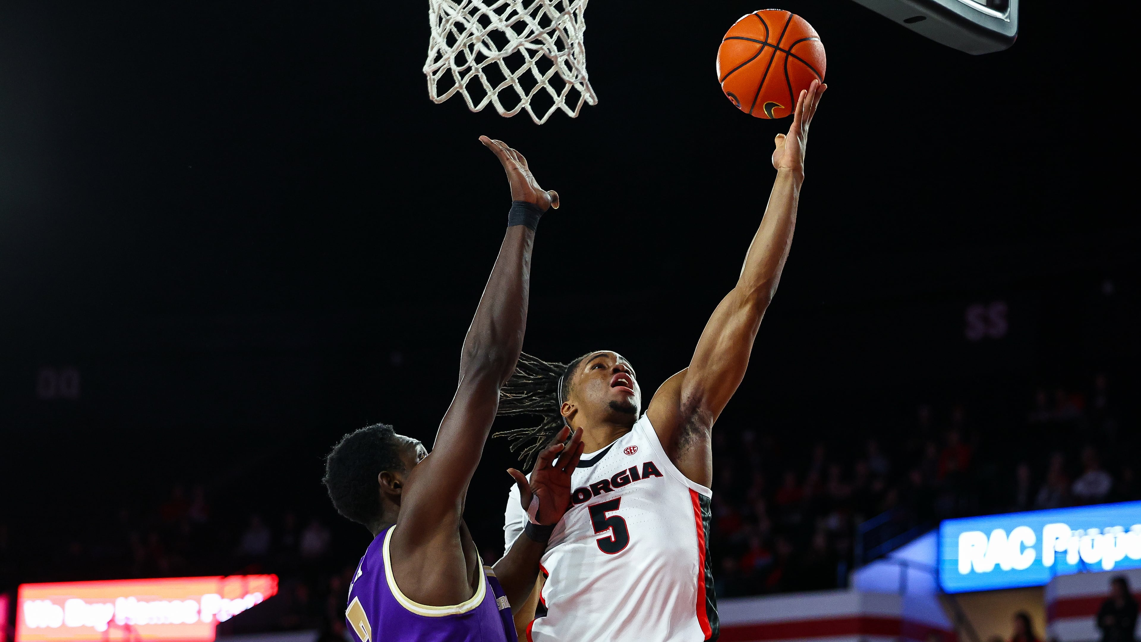 Georgia guard Jeremiah Wilkinson (5) shoots over Western Carolina center Abdulai Fanta Kabba, left, during the first half of an NCAA college basketball game, Thursday, Dec. 18, 2025, in Athens, Ga. (AP Photo/Colin Hubbard)