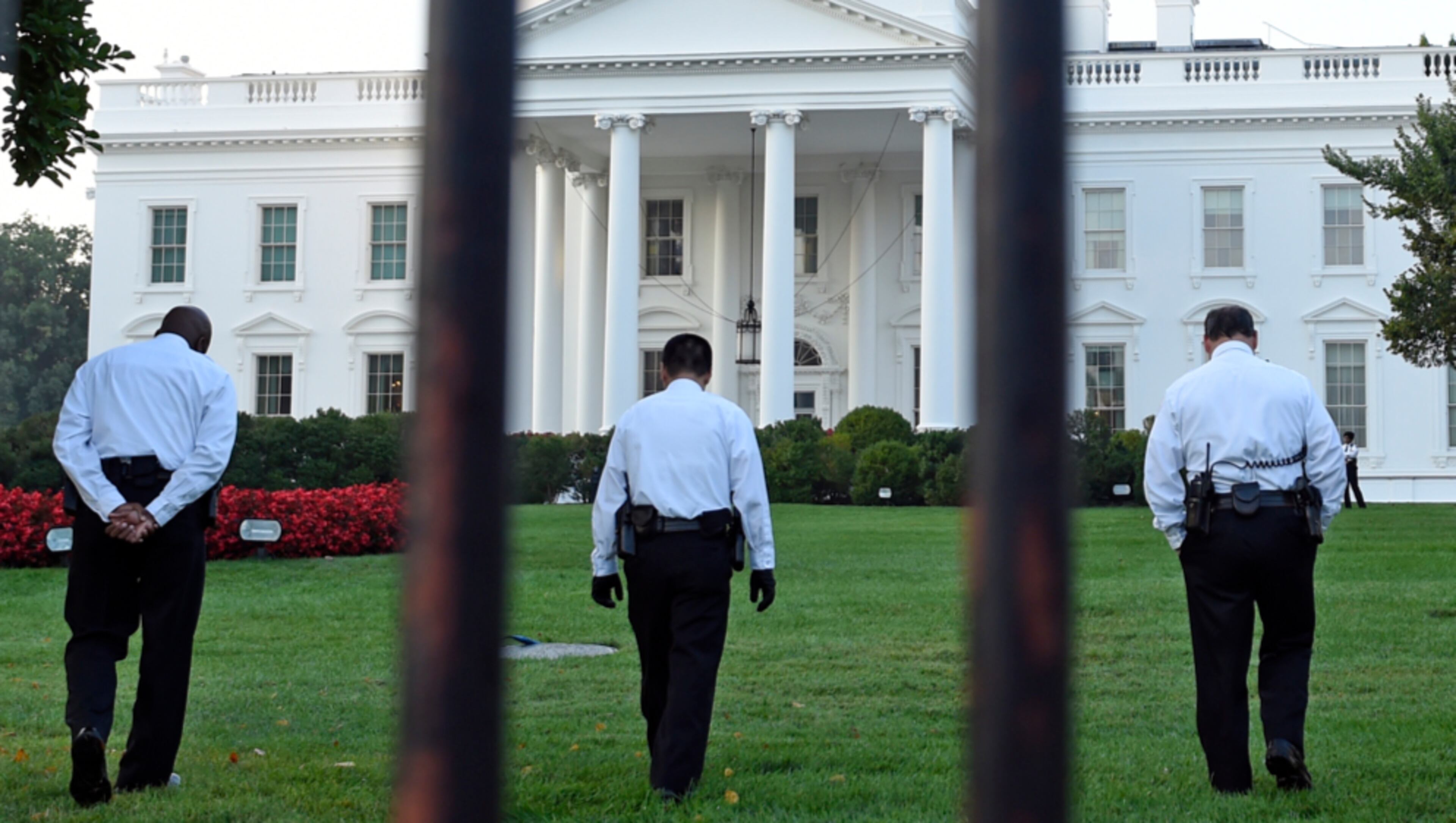 In this file photo, officers are seen checking the grounds of the White House in Washington. President Joe Biden has no public events scheduled today.