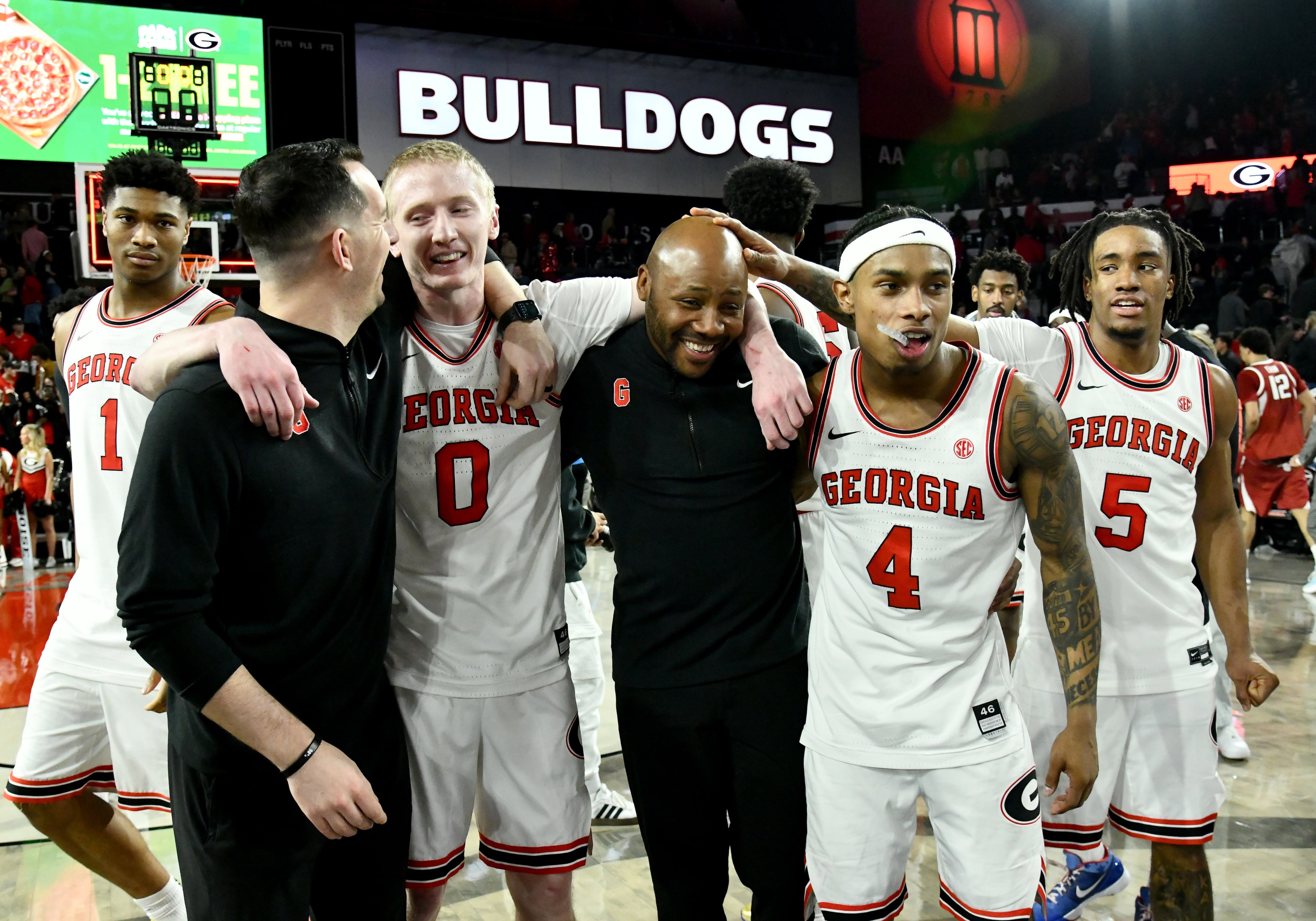 Georgia guard Blue Cain (front, second from left) and Georgia guard Marcus Millender (second from right) celebrate with coaching staff after Georgia beat Arkansas in an NCAA college basketball game at Stegeman Coliseum, Saturday, Jan. 17, 2026, in Athens. Georgia won 90-76 over Arkansas. (Hyosub Shin/AJC)