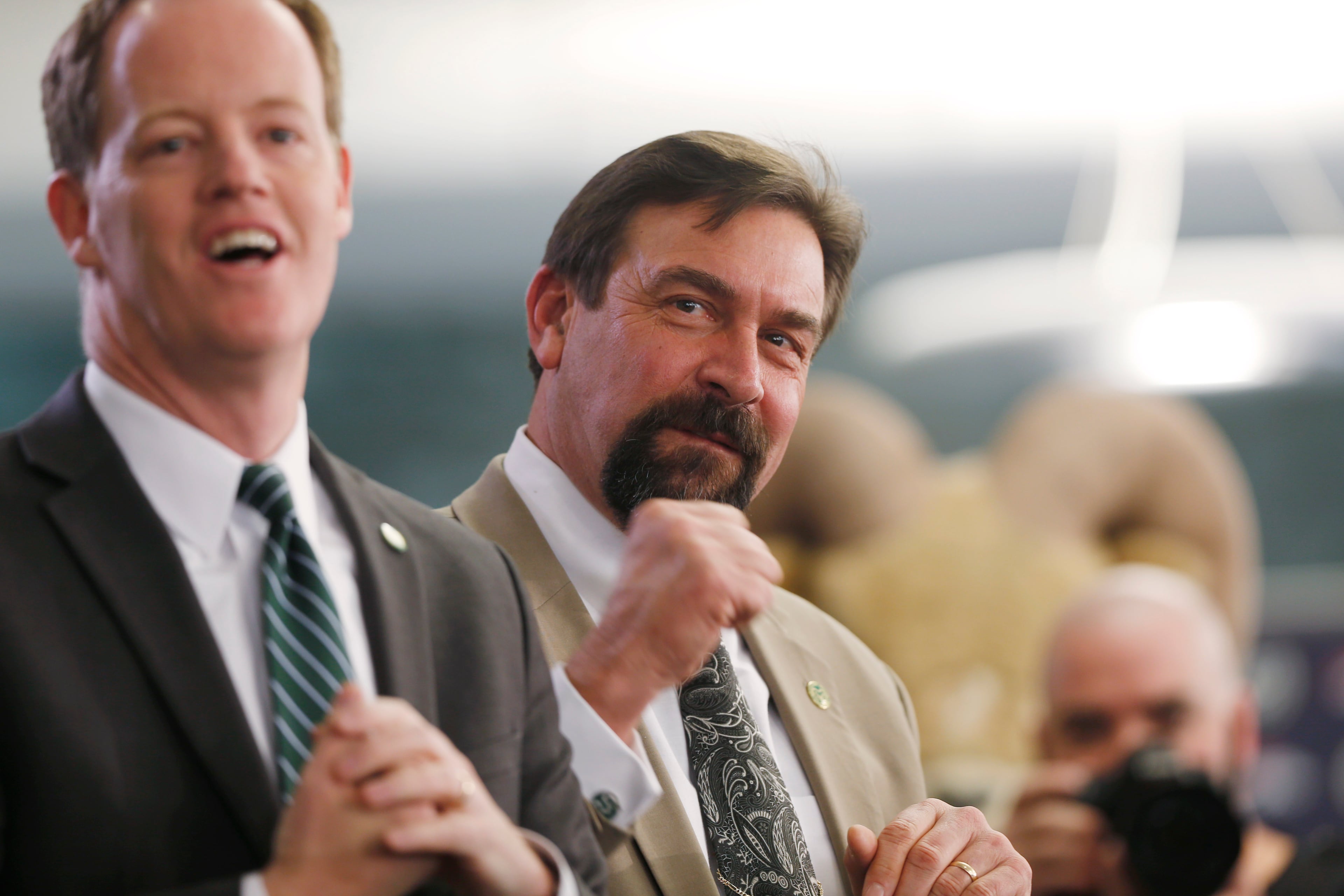 Colorado State athletic director John Morris, left, and Tony Frank, president of the university react as Mike Bobo is introduced as the new head football coach at the university at a news conference Tuesday, Dec. 23, 2014, in Fort Collins, Colo. Bobo, who was the offensive coordinator at the University of Georgia, succeeds Jim McElwain, who left after three seasons to become the head football coach at the University of Florida. (AP Photo/David Zalubowski)