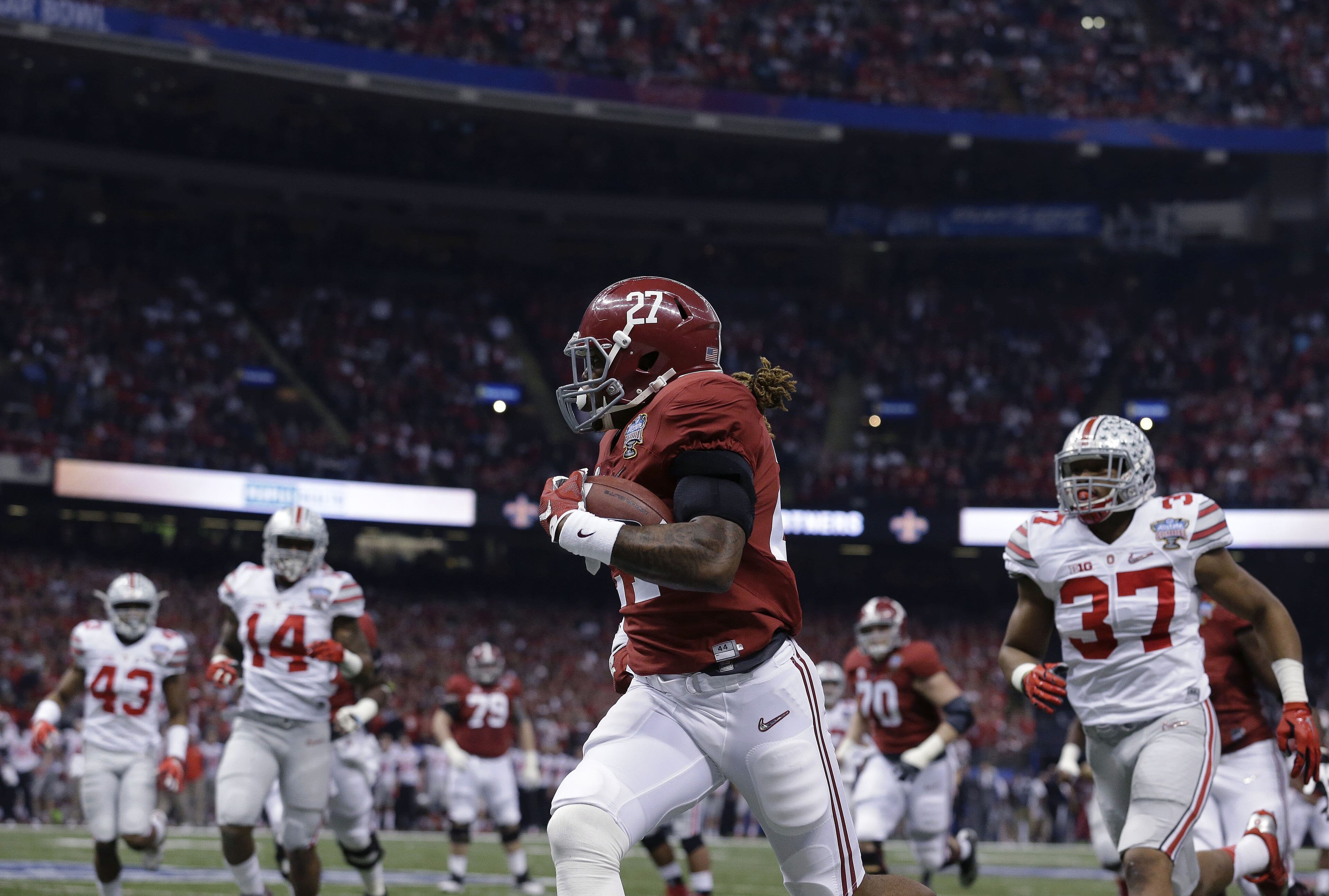 Alabama running back Derrick Henry (27) runs toward the end zone against Ohio State linebacker Joshua Perry (37) in the first half of the Sugar Bowl NCAA college football playoff semifinal game, Thursday, Jan. 1, 2015, in New Orleans. Henry scored a touchdown on the play. (AP Photo/Brynn Anderson)