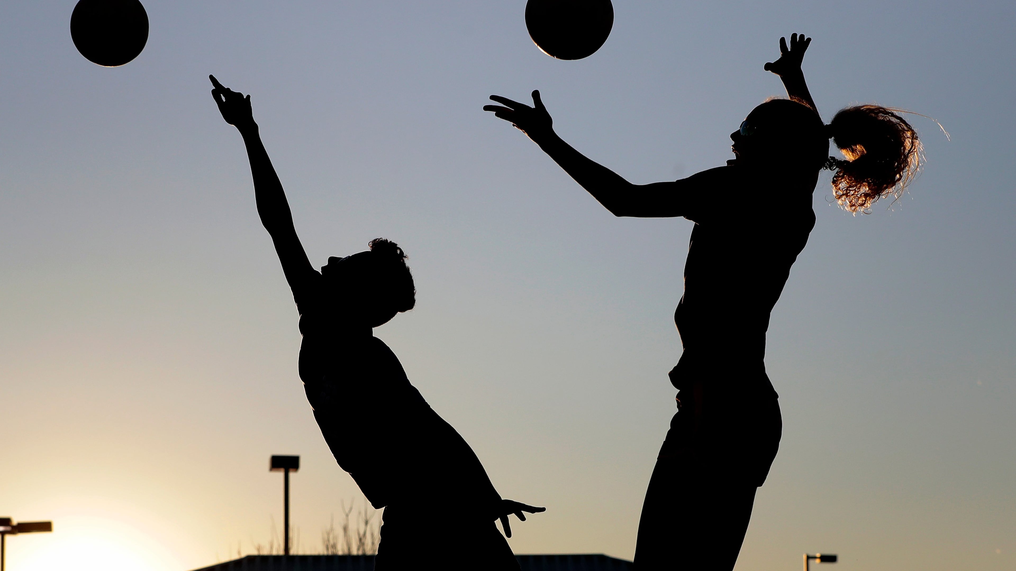 FILE - Friends practice volleyball at a local park in Gilbert, Ariz., March 15, 2020. (AP Photo/Matt York, File)