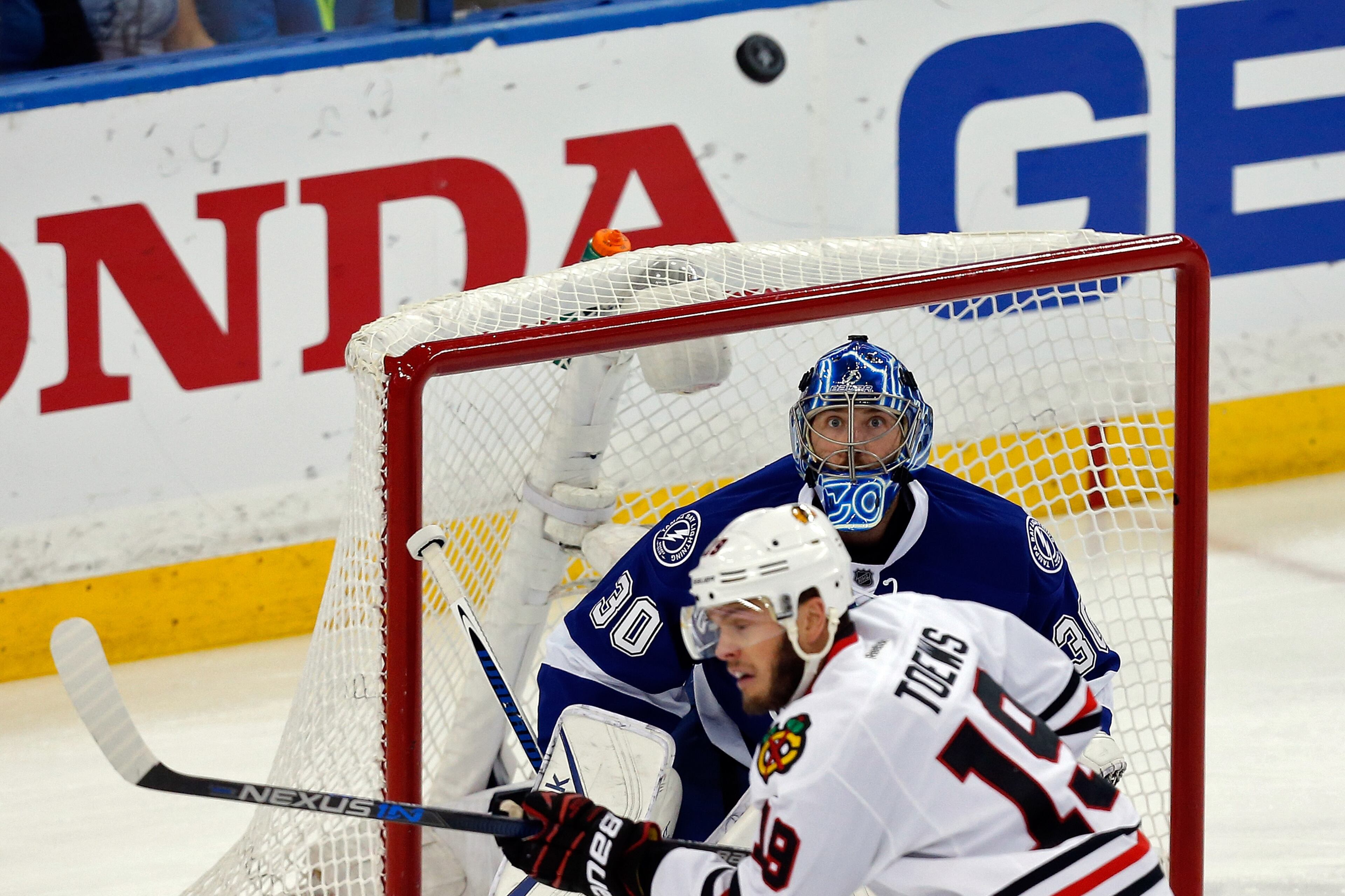 TAMPA, FL - JUNE 13: Ben Bishop #30 of the Tampa Bay Lightning looks at a puck as Jonathan Toews #19 of the Chicago Blackhawks skates in front of him during Game Five of the 2015 NHL Stanley Cup Final at Amalie Arena on June 13, 2015 in Tampa, Florida. (Photo by Mike Carlson/Getty Images)
