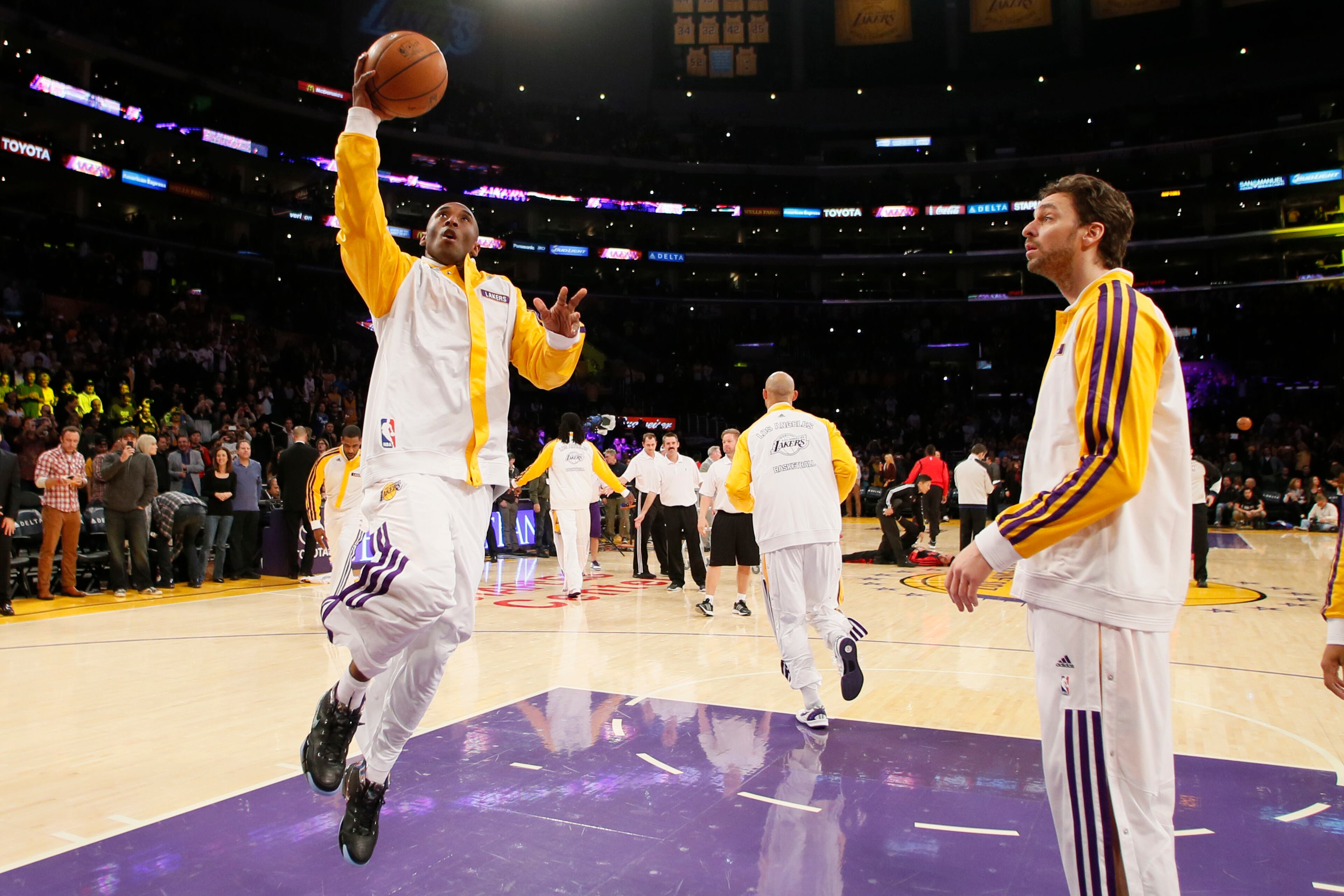 Los Angeles Lakers' Kobe Bryant makes his first layup in warm-ups as Pau Gasol, right, of Spain, looks on before the NBA basketball game against the Toronto Raptors in Los Angeles, Sunday, Dec. 8, 2013. Bryant is expected to make his long-awaited return from a torn left Achilles tendon injury from April 12th.