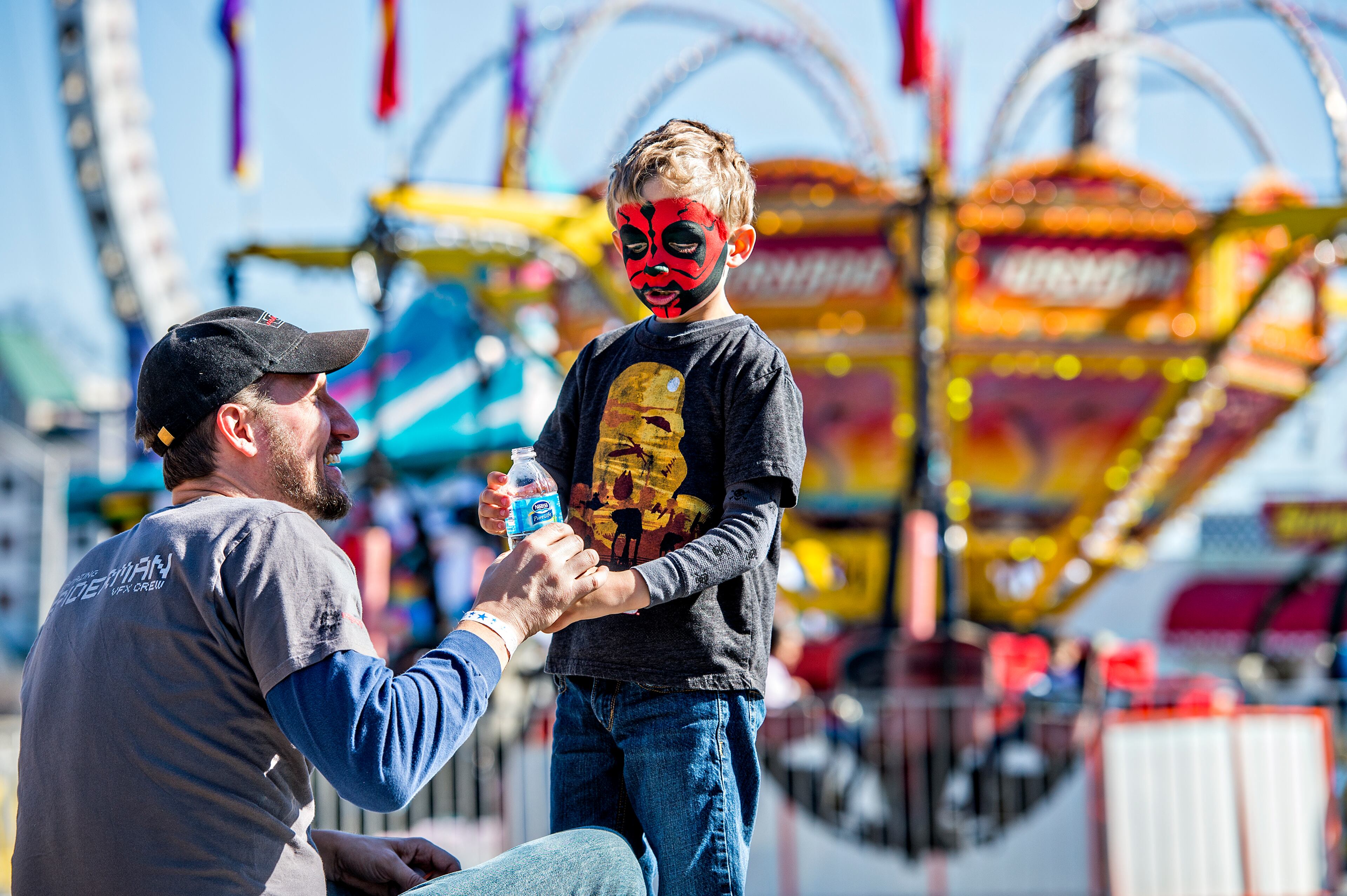Chase Deren (right) takes a short water break with his father, Eric, before getting on another ride at the Atlanta Fair near Turner Field on Saturday, Feb. 27, 2016. JONATHAN PHILLIPS / SPECIAL