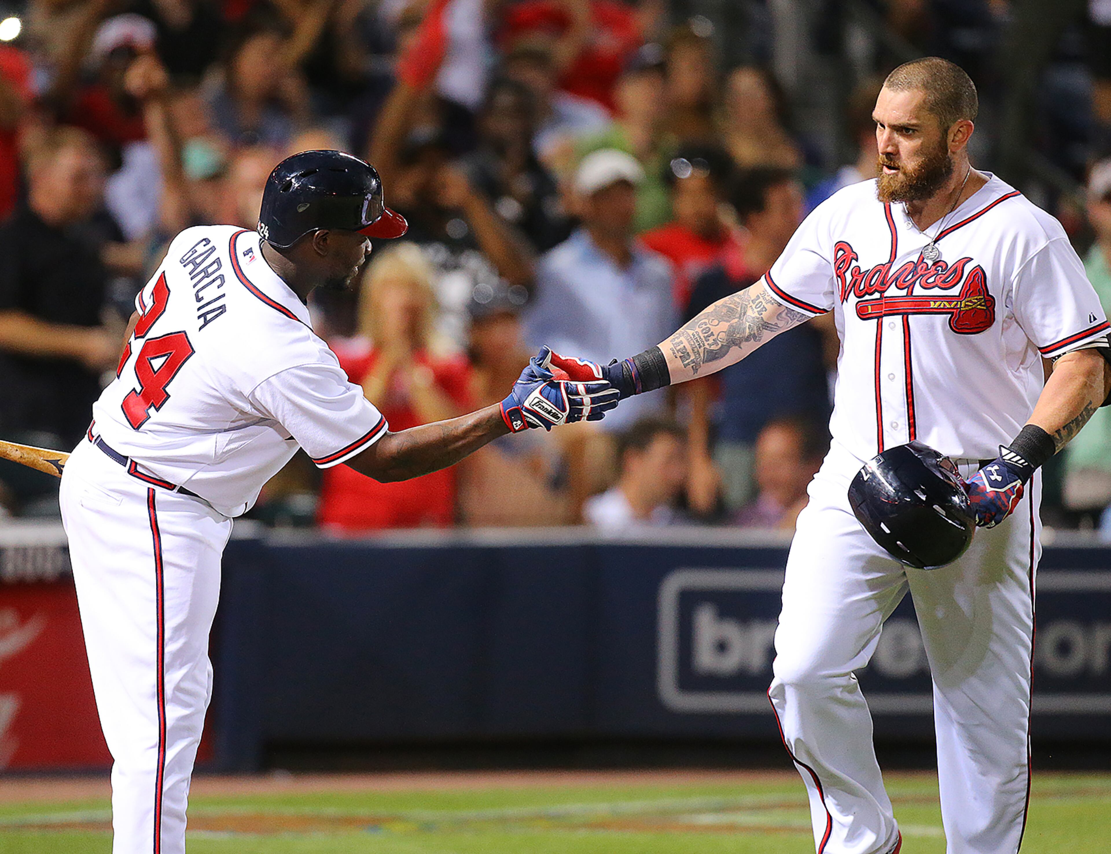 Braves Jonny Gomes (right) gets five at home from Adonis Garcia after hitting a solo home run to take a 2-0 lead over the Rockies during the sixth inning in a baseball game on Wednesday, August 26, 2015, in Atlanta. Garcia followed up with a homer of his home to take a 3-0 lead. Curtis Compton / ccompton@ajc.com