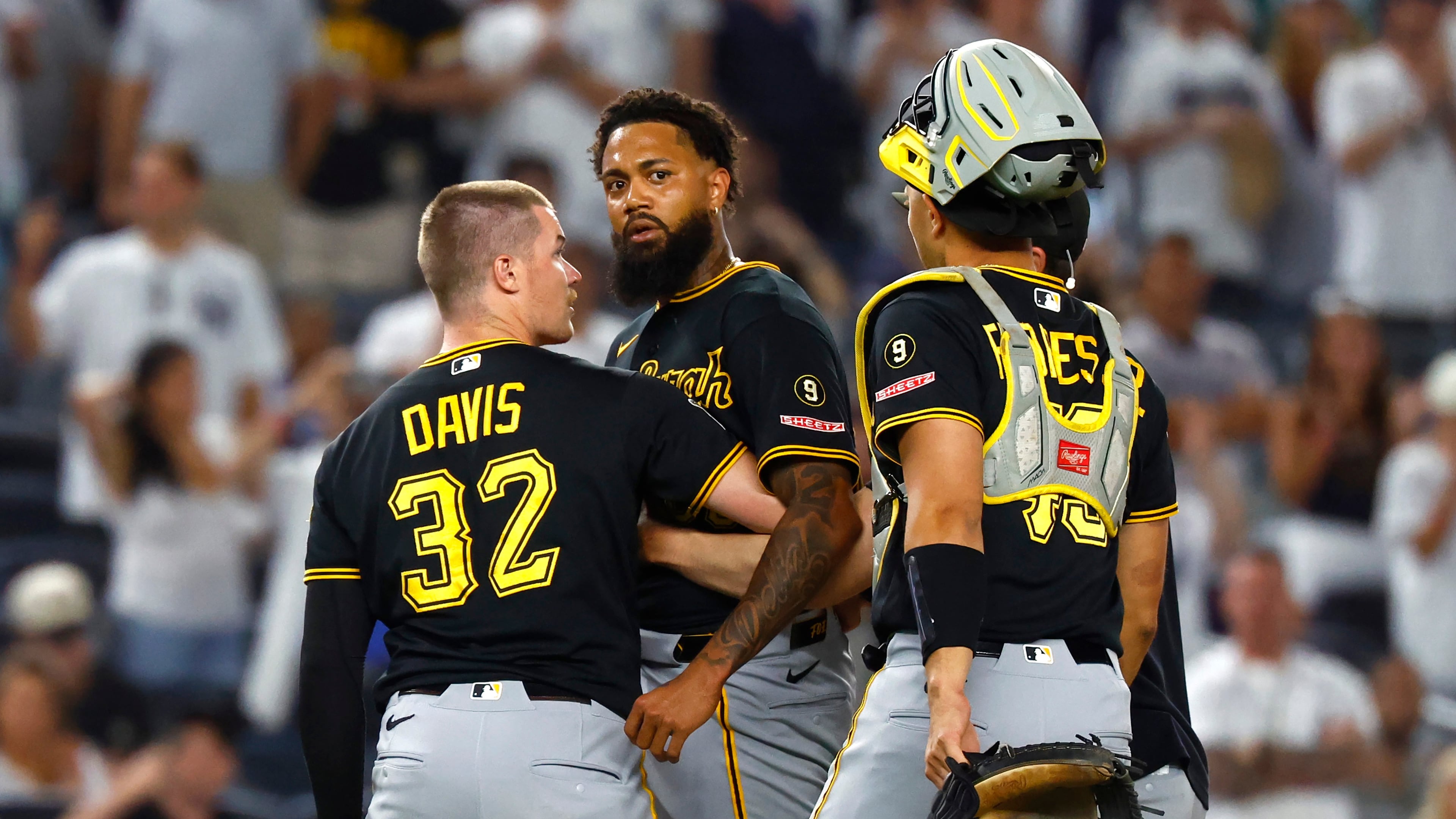 Pittsburgh Pirates catchers Henry Davis (32) and Rafael Flores Jr. keep pitcher Dennis Santana from going after New York Yankees' José Caballero during the ninth inning of a baseball game, Monday, July 20, 2026 in New York. (AP Photo/Noah K. Murray)