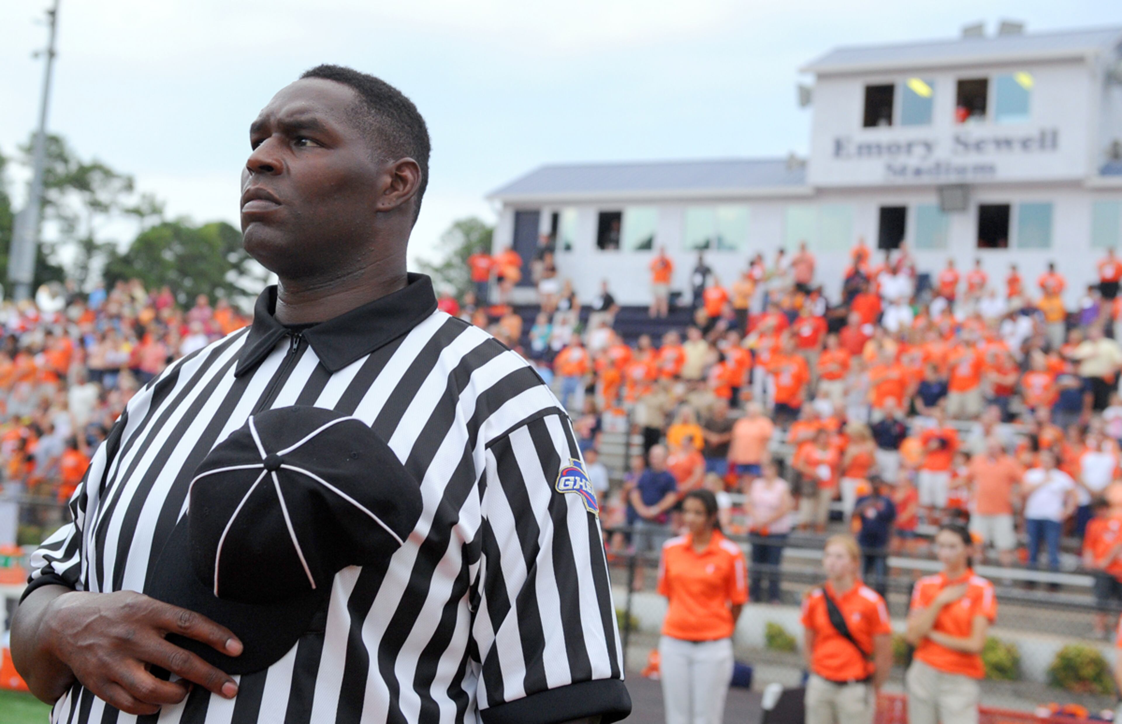 Bob Whitfield stands for the National Anthem before offciating the North Cobb-Alpharetta game in 2011. Jonathan Phillips / Special